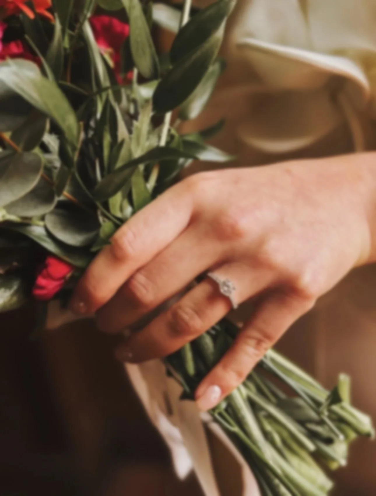A warm, autumnal wedding bouquet held by an Irish Bride with her engagement ring on show. Shot in the Kees Hotel in Stranorlar, Donegal