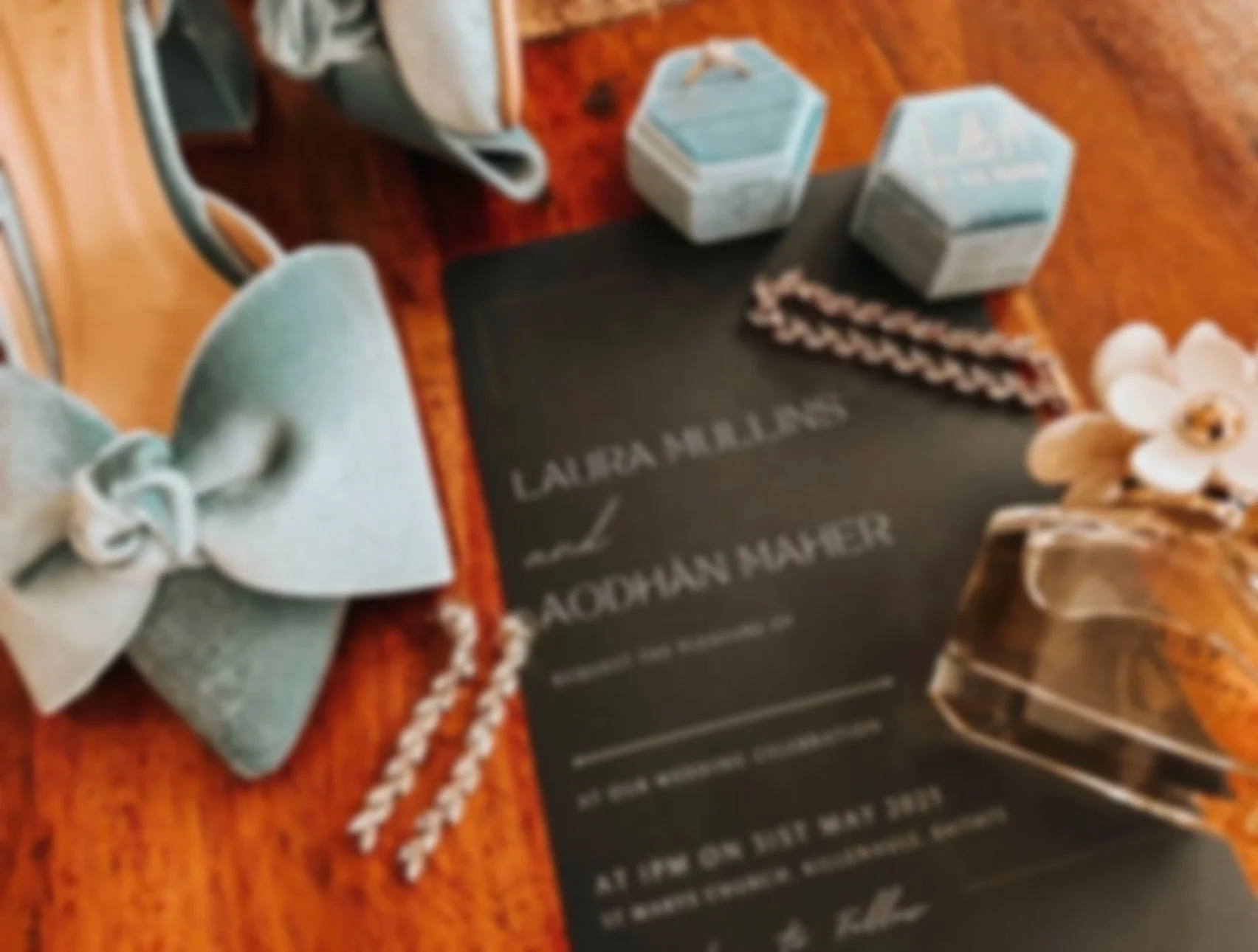 A wedding flat lay with velvet blue wedding shoes, and a black invitation. There is jewellery & other sentimental pieces around the invite. Captured in County Louth by Grey Acre Studios Wedding Content Creator Ireland