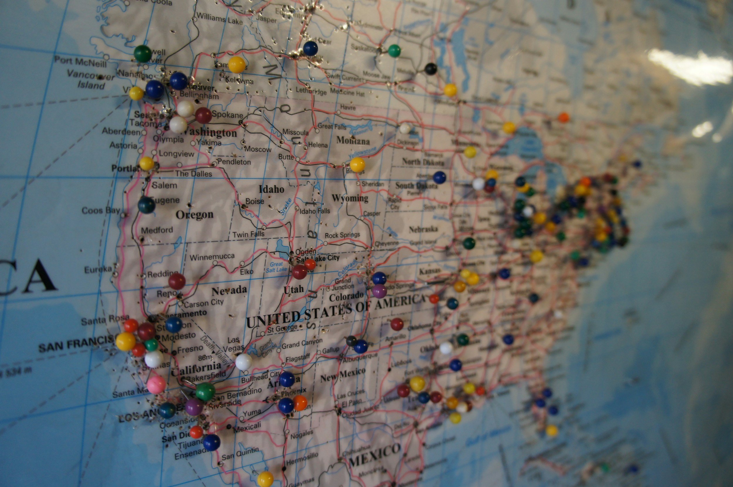 Close-up of a map of the United States with colorful pins marking various locations.