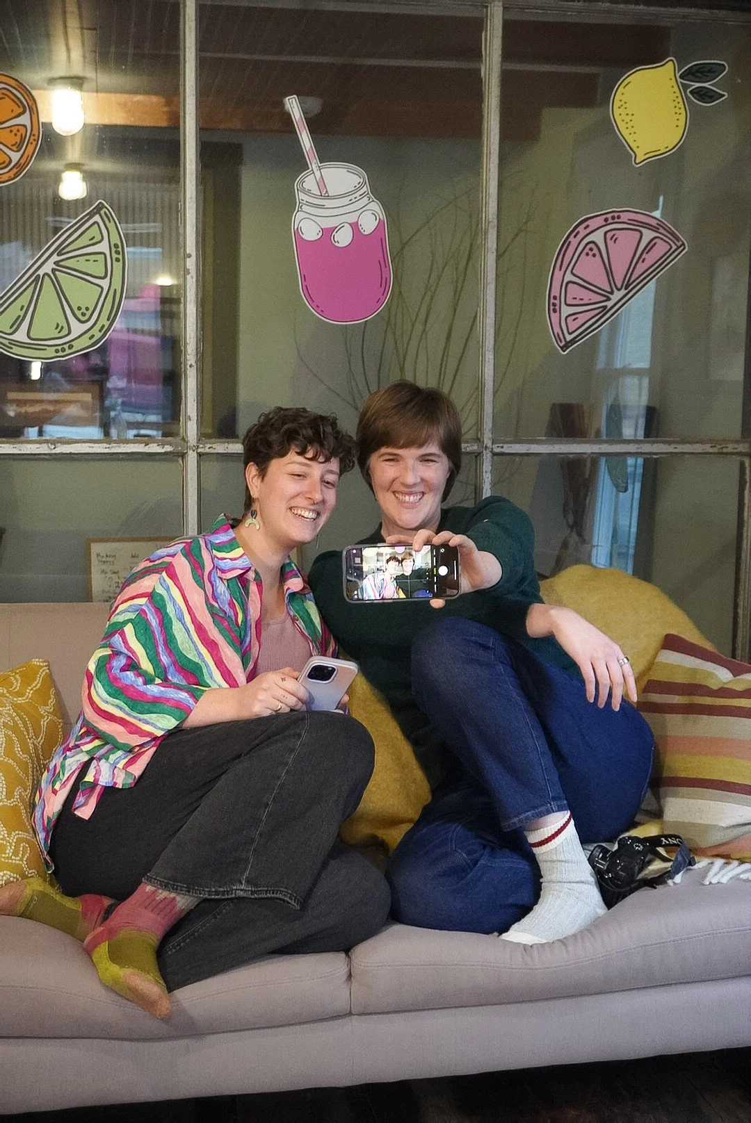 Meghan and Emily are taking a selfie to post on social media