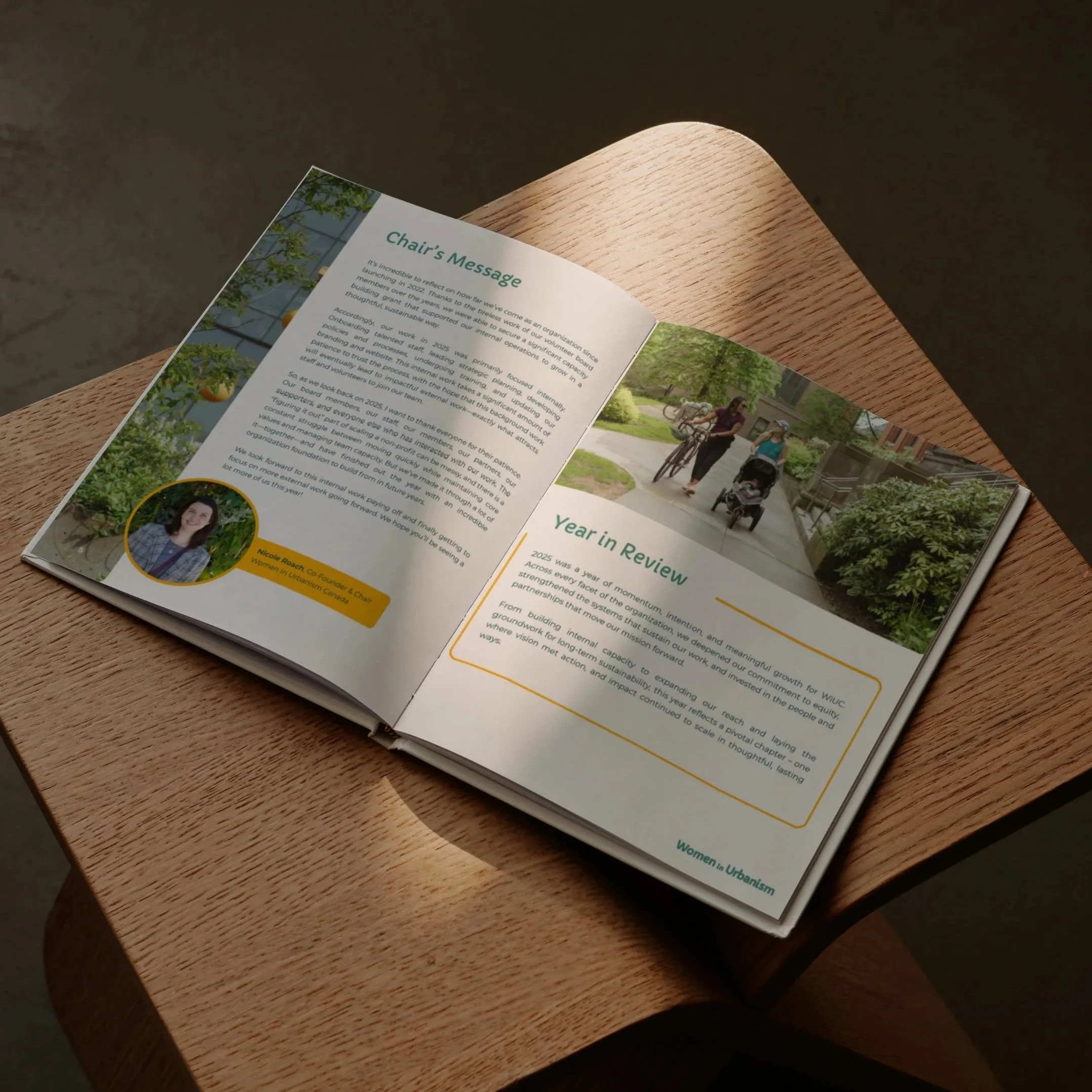 An annual report designed by Lemonade Co. for Women in Urbanism is sitting open on a wooden table