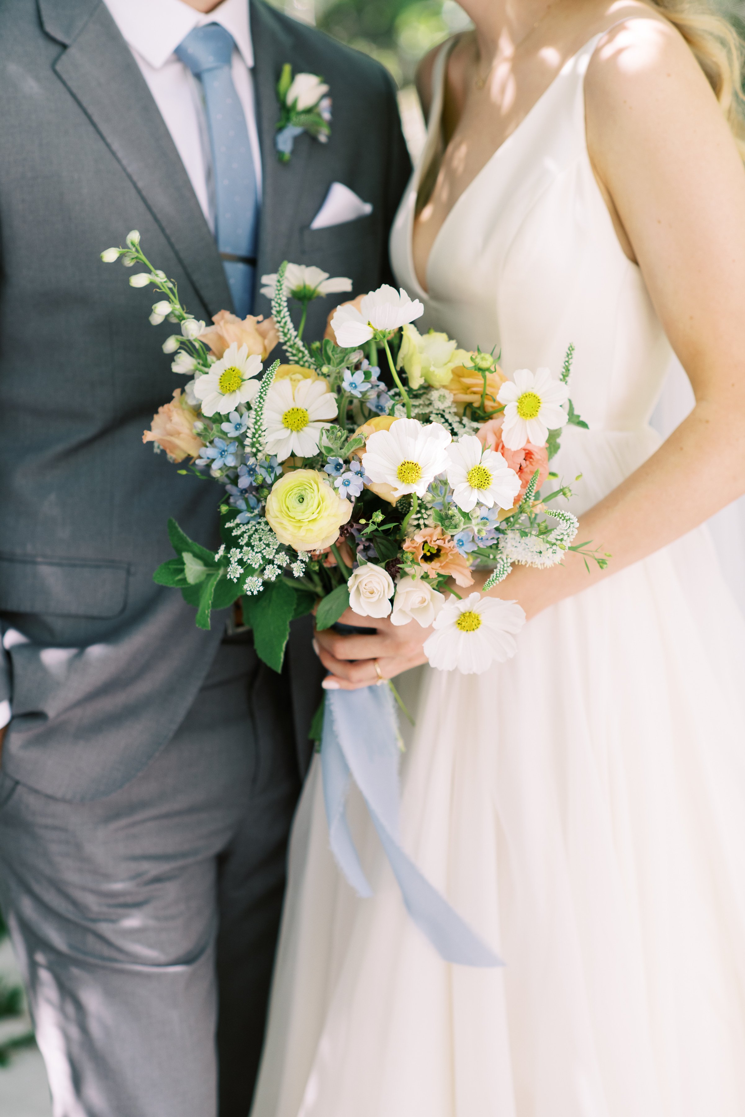 Bride and groom standing together with bouquet