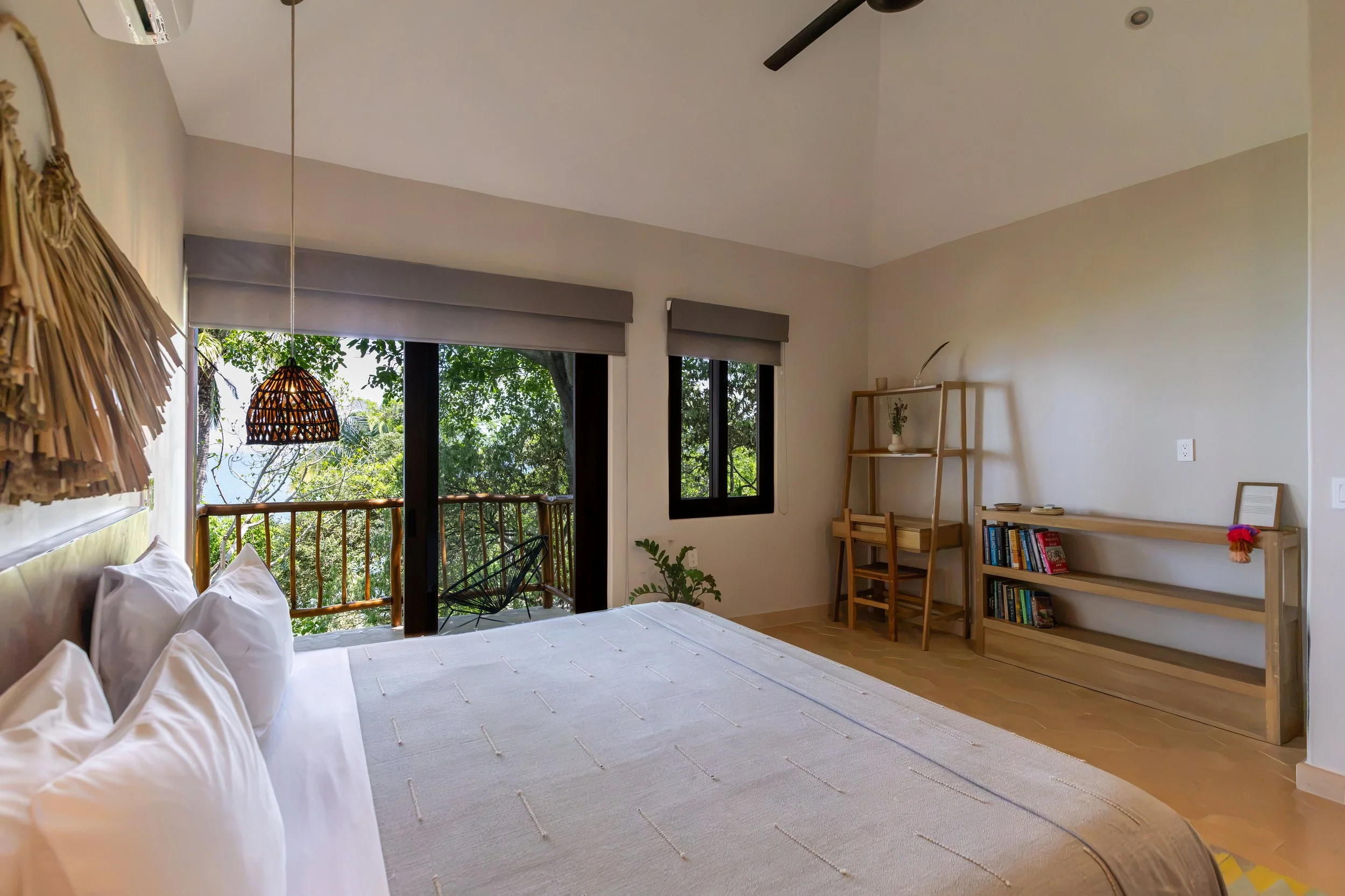 Living room with large windows, wooden dining table with chairs, beige sofa, and artwork on the wall. Perfect for family satys.