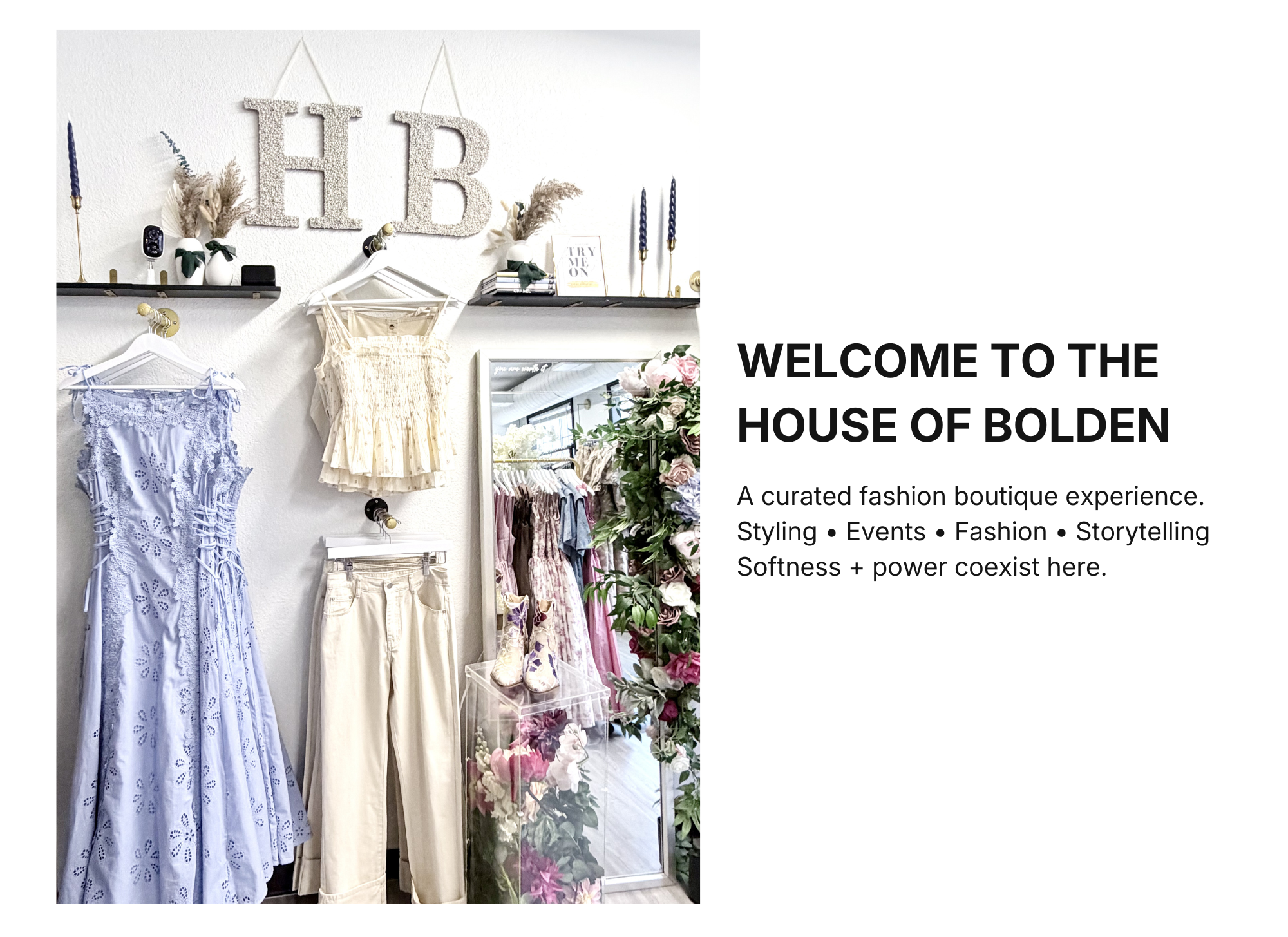 Display of women's clothing, including a light blue lace dress, cream pants, and a beige top, inside a boutique with decorative flowers and a mirror. Signage reads 'WELCOME TO THE HOUSE OF BOLDEN' and 'A curated fashion boutique experience'.