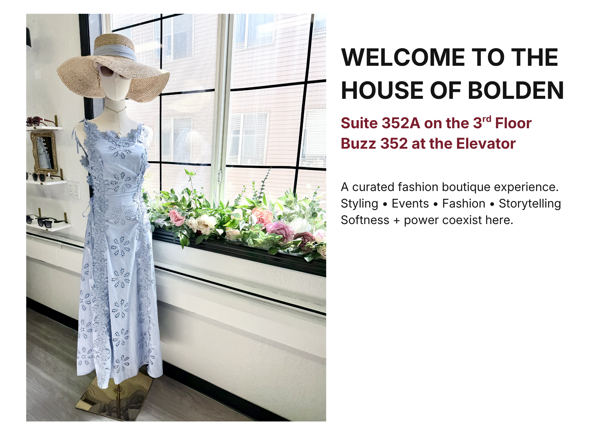 A fashion boutique display with a mannequin dressed in a white lace dress and a wide-brimmed straw hat, positioned near a window with plants and flowers on the windowsill.