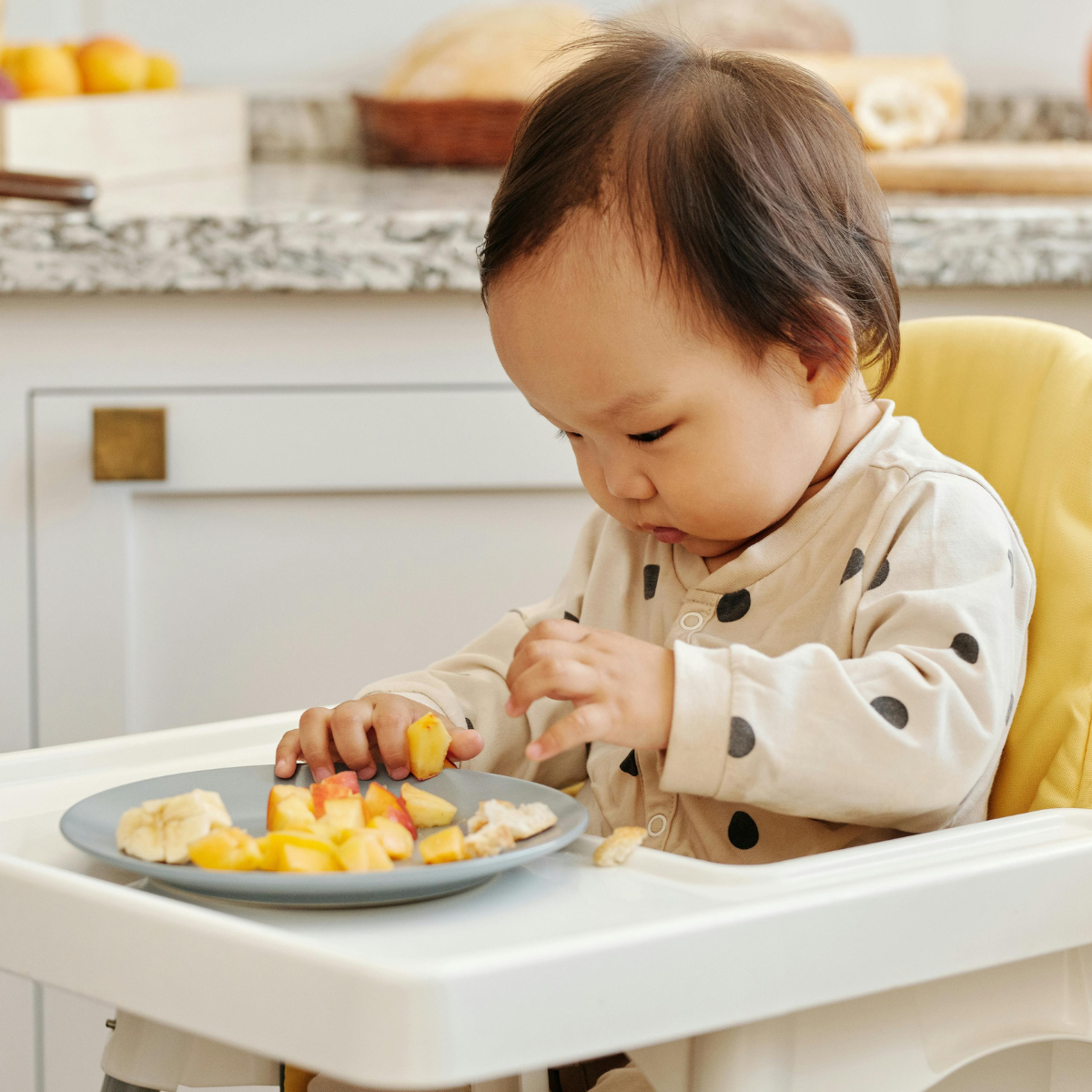 Baby beginning solid foods with parent support, focusing on readiness and positive early feeding experiences and reducing choking risk