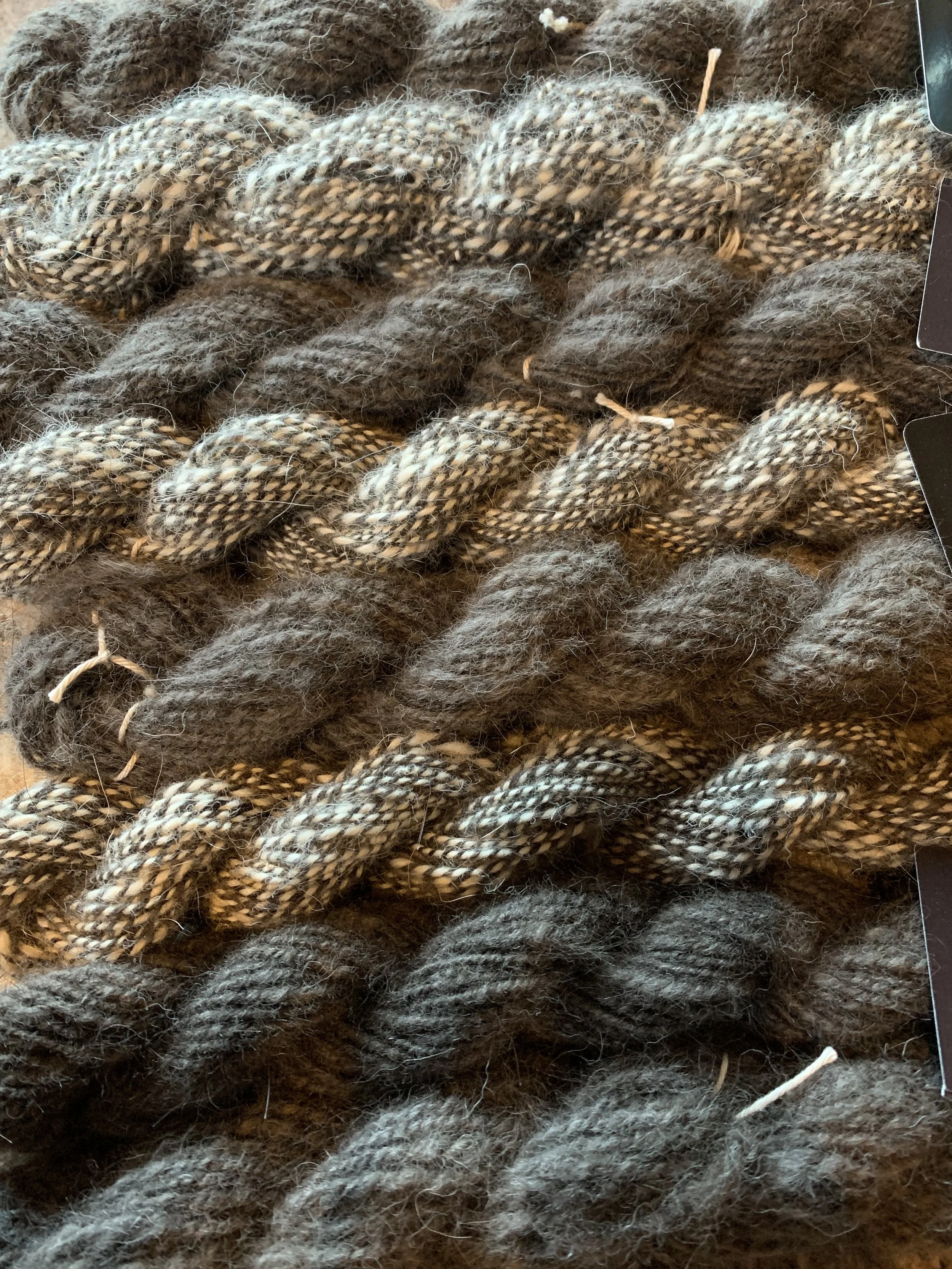 hand spun alaskan husky undercoat yarn in black and white striped, and black.