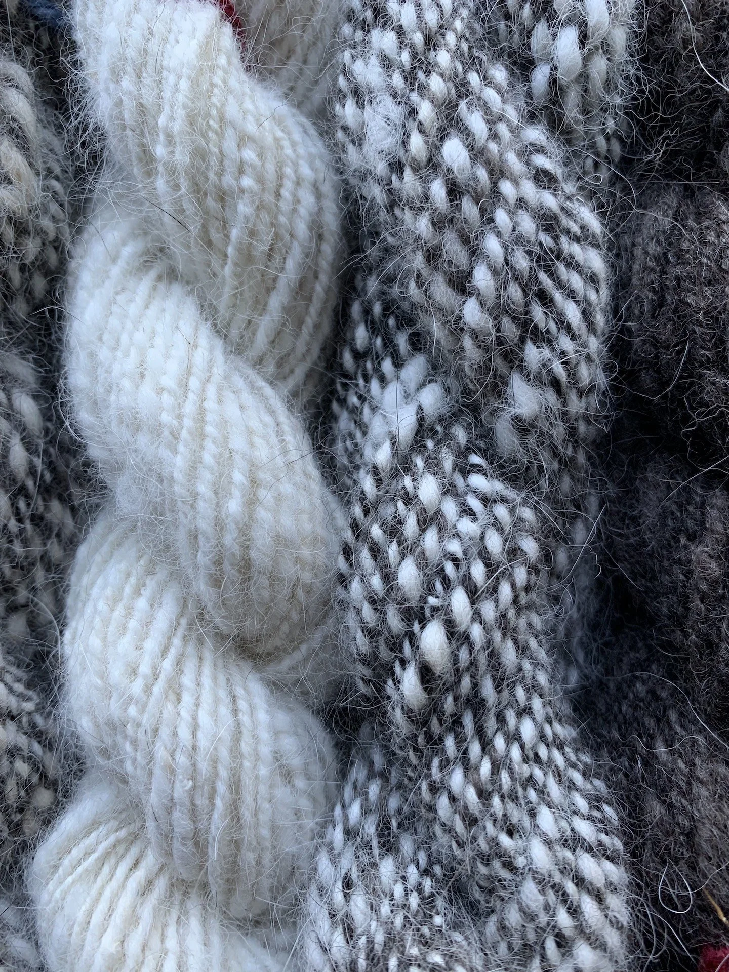 Hand spun alaskan husky yarn. Many skeins in black and white striped, white and black.
