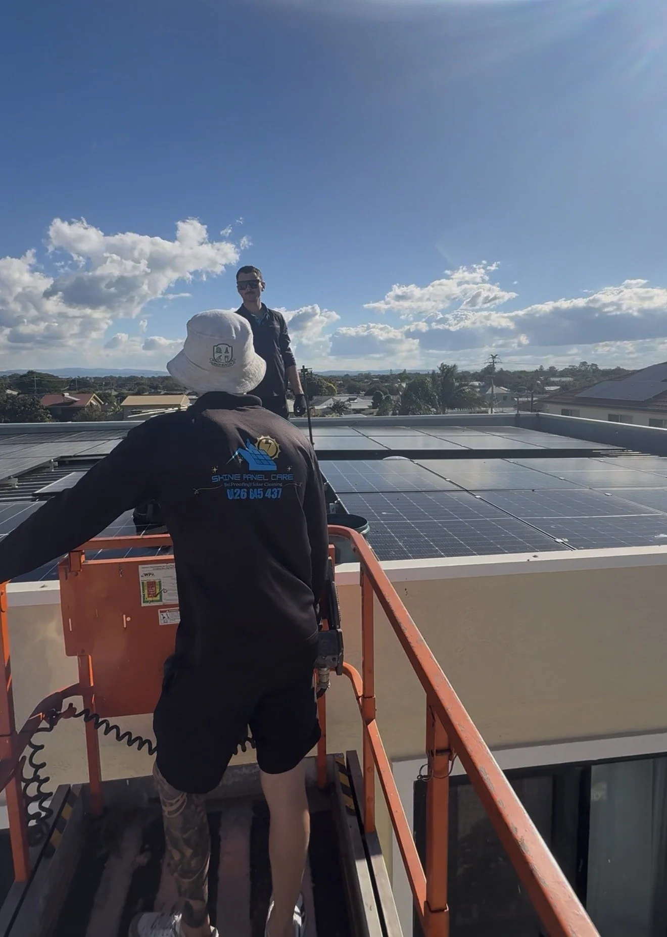 Two Shine Panel Care workers inspecting rooftop solar panels during a bird proofing and solar maintenance service