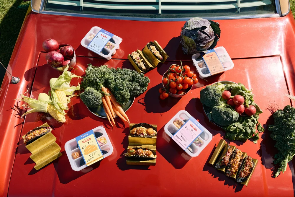 Cheeky tacos and fresh produce on a red car bonnet