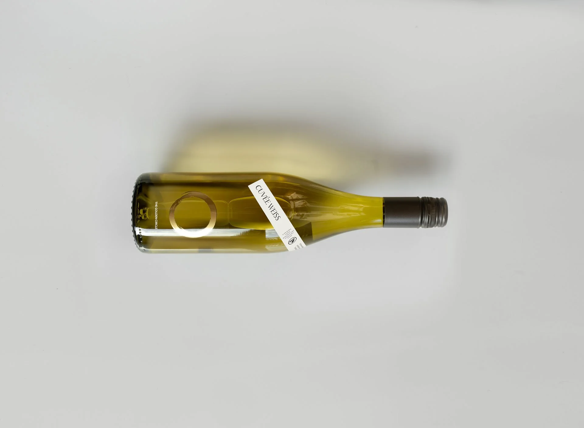 Flasche mit dem Etikett „Cuvée Weiss“ auf einem weißen Hintergrund platziert.