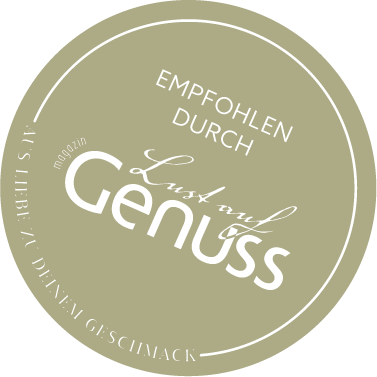 Rundes Siegel mit der Aufschrift "Empfohlen durch Genuss" auf einem olivgrünen Hintergrund.