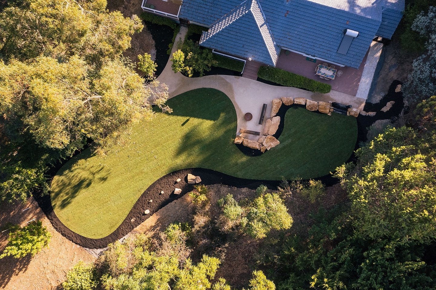 A contrast between the new, crisp landscaping and natural rural vegetation. The new saplings are growing to elevate the space and blend with the surrounds.