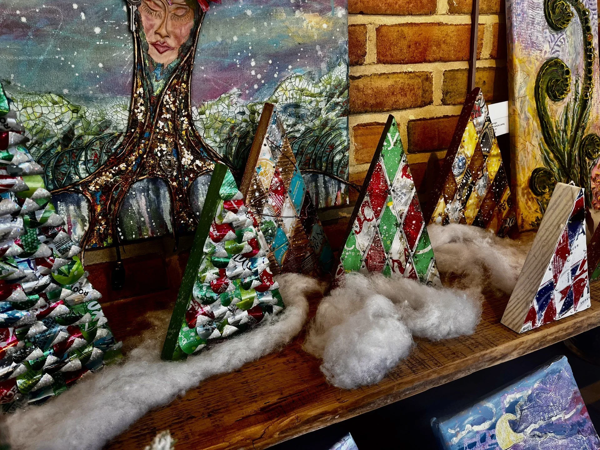 Colorful mixed-media holiday tree artworks displayed at the Holiday Gift Show.