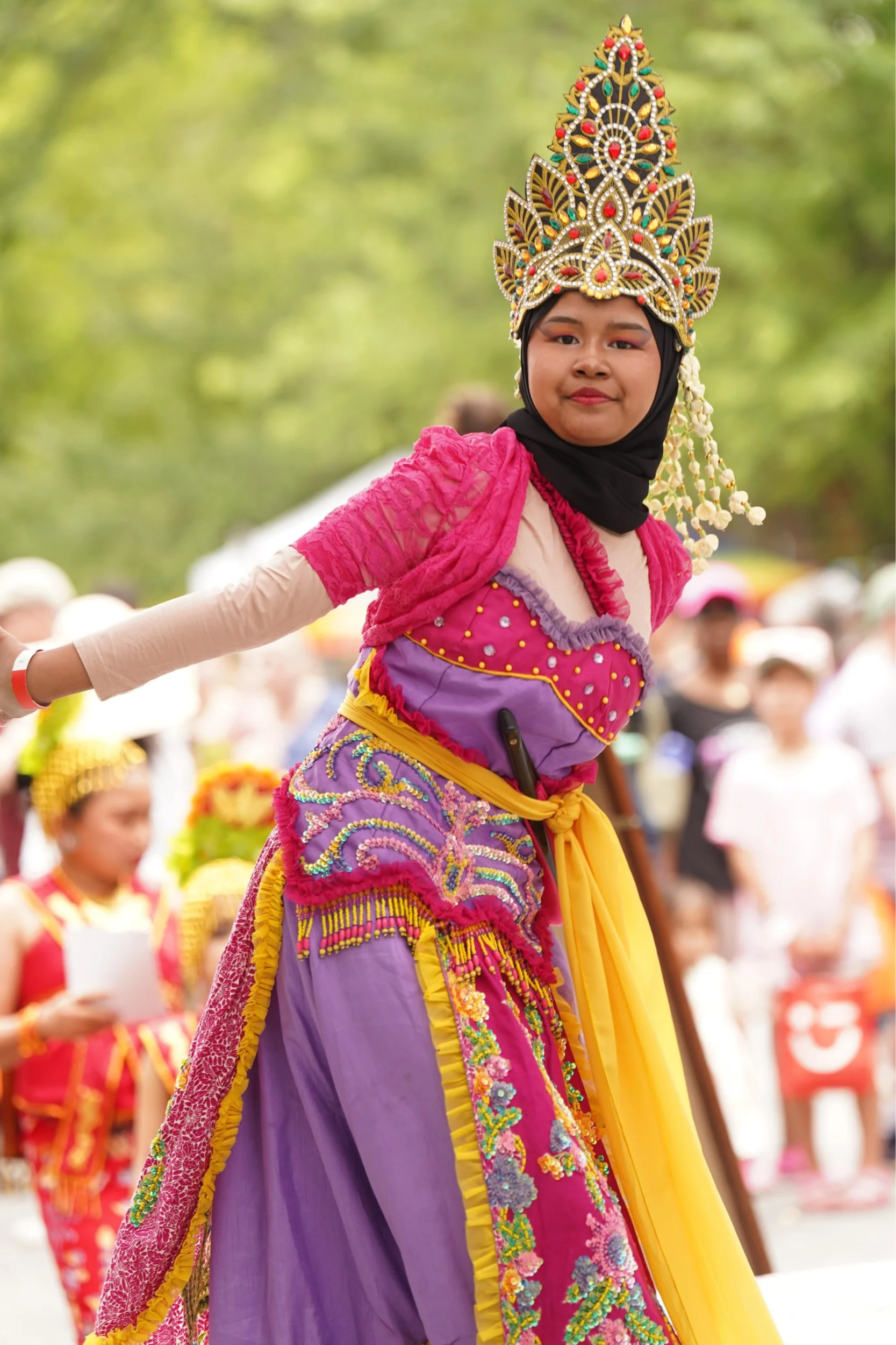 A performer in a colorful costume at the Strawberry Festival.