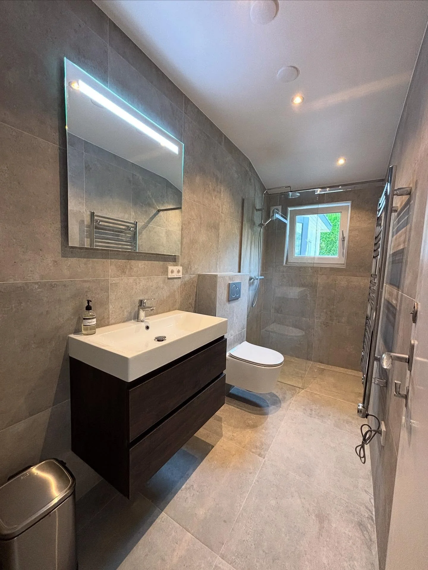 Our team had the pleasure of creating this stylish and modern bathroom.

We took care of everything from start to finish:
	&bull;	Replaced all plumbing and drains
	&bull;	Leveled walls and installed new ceilings
	&bull;	Added a brand-new window and f