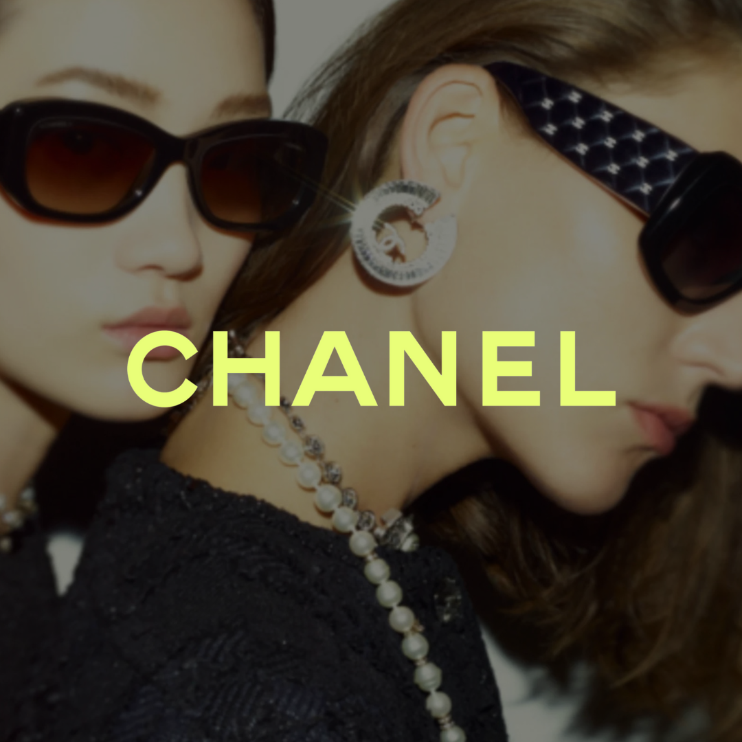 Close-up of two women wearing sunglasses and jewelry, with the word "Chanel" overlaid.