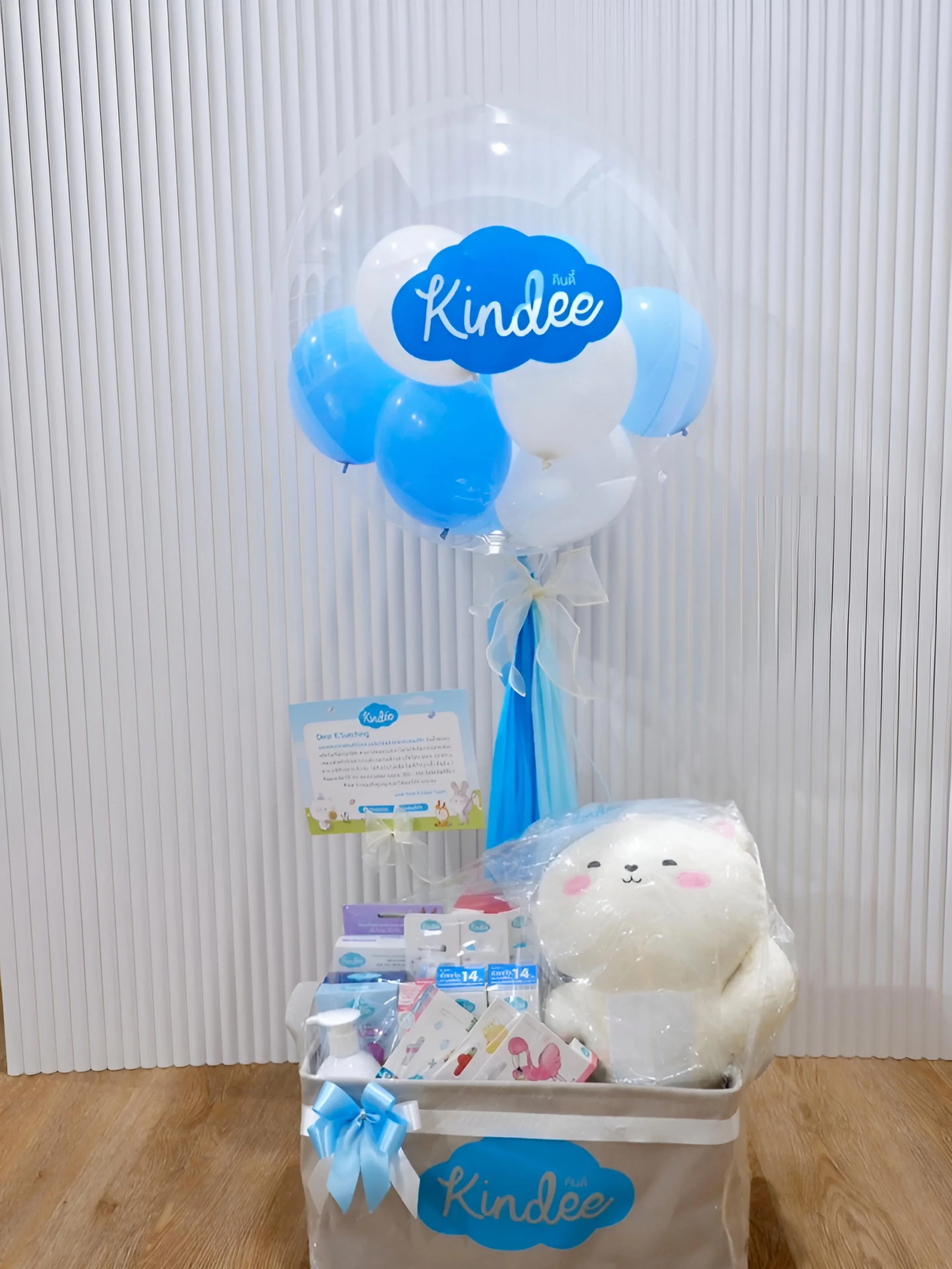 Hamper with newborn products tied with a bubble balloon and customized card