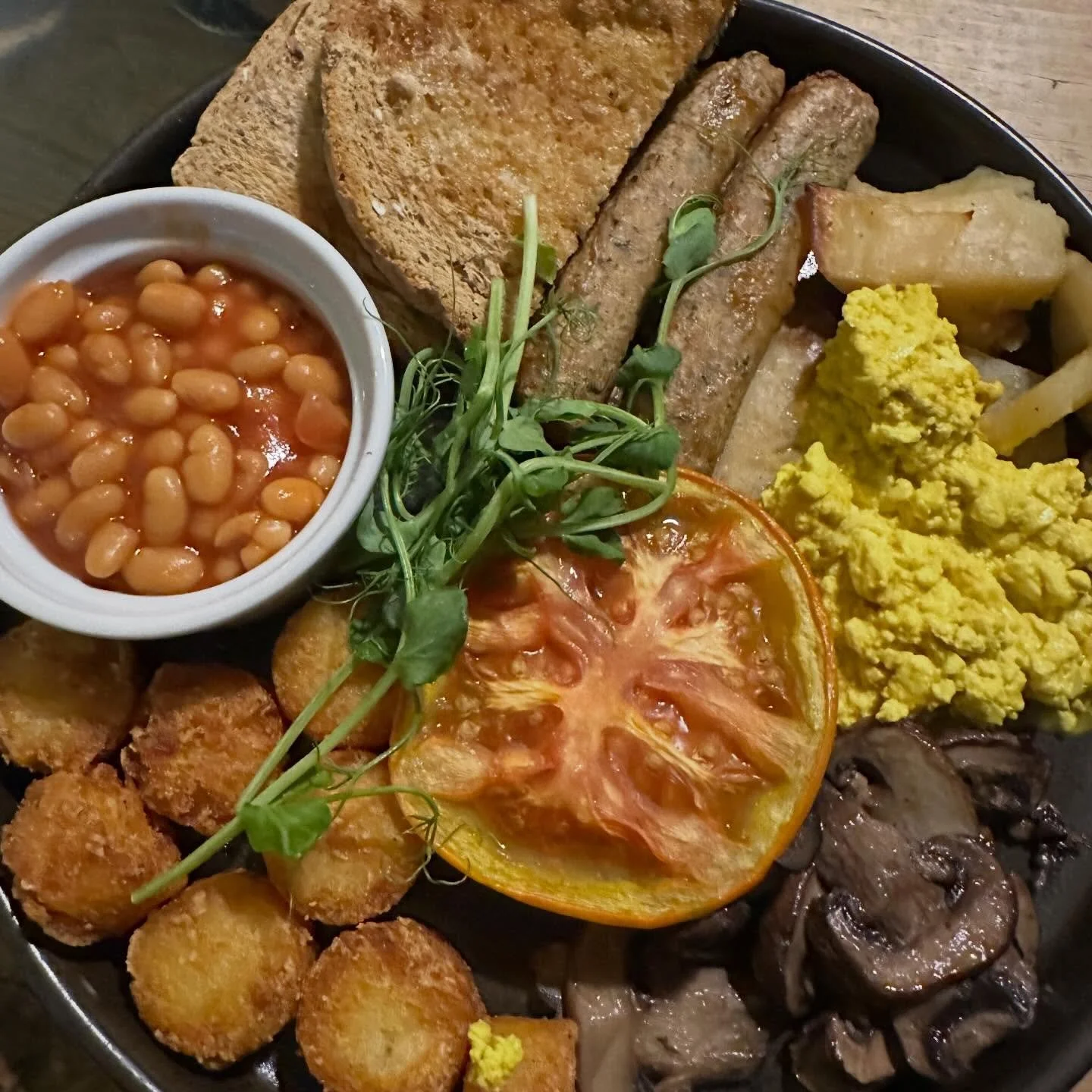 @super_natural_newcastle looked after us on a cold and rainy Sunday morning. One full English breakfast with Sausage, scrambled tofu, potato, rosti bites, beans, tomato, mushrooms and bloomer toast. 🍞 And one breakfast wrap filled to burst with rost