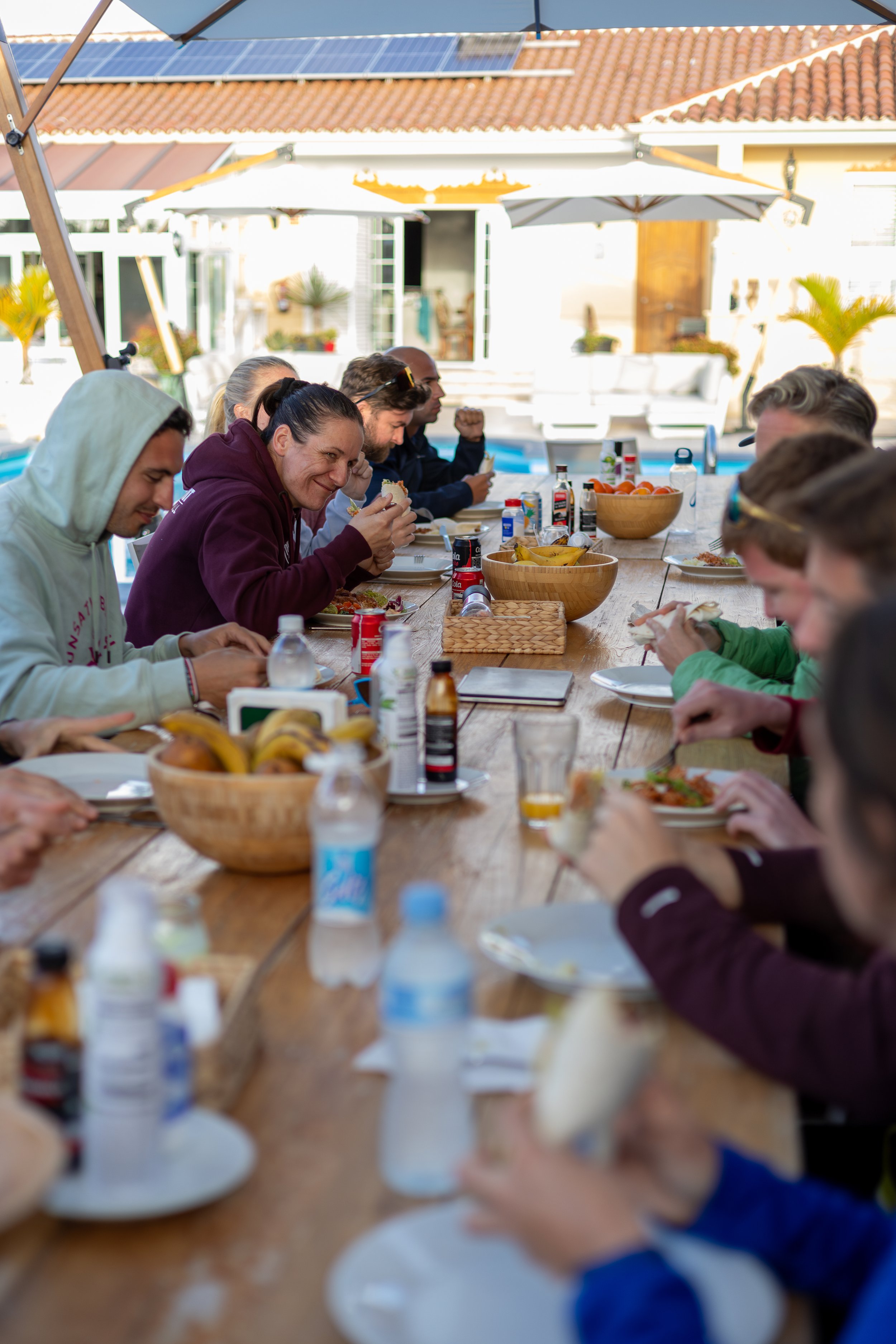 Beachboard Hacienda kitchen customers eating around long table, meal time.jpg