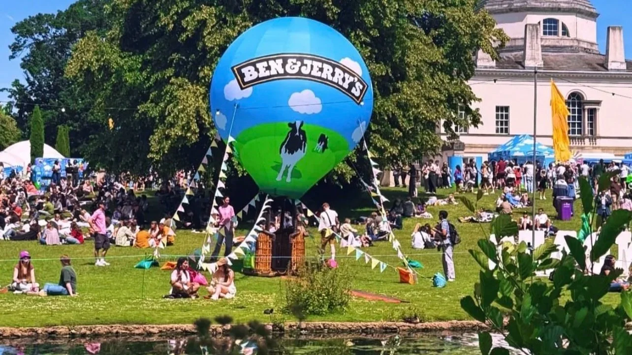 Ben & Jerry's branded hot air balloon inflatable display at an outdoor event with crowds seated on the grass