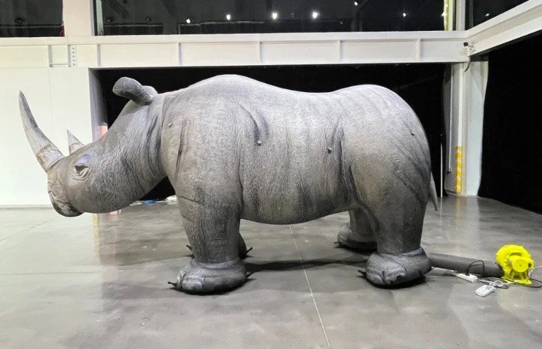 Giant inflatable rhino replica inside an exhibition or event venue