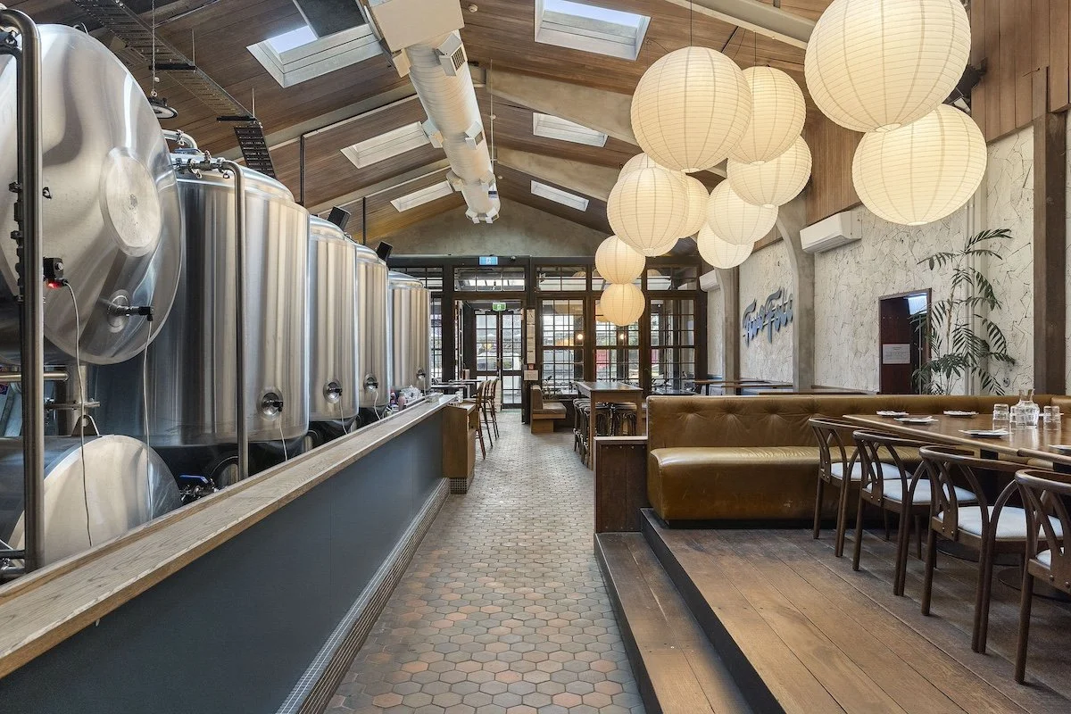 A working brewery on the left and a raised seating area and bar on the right