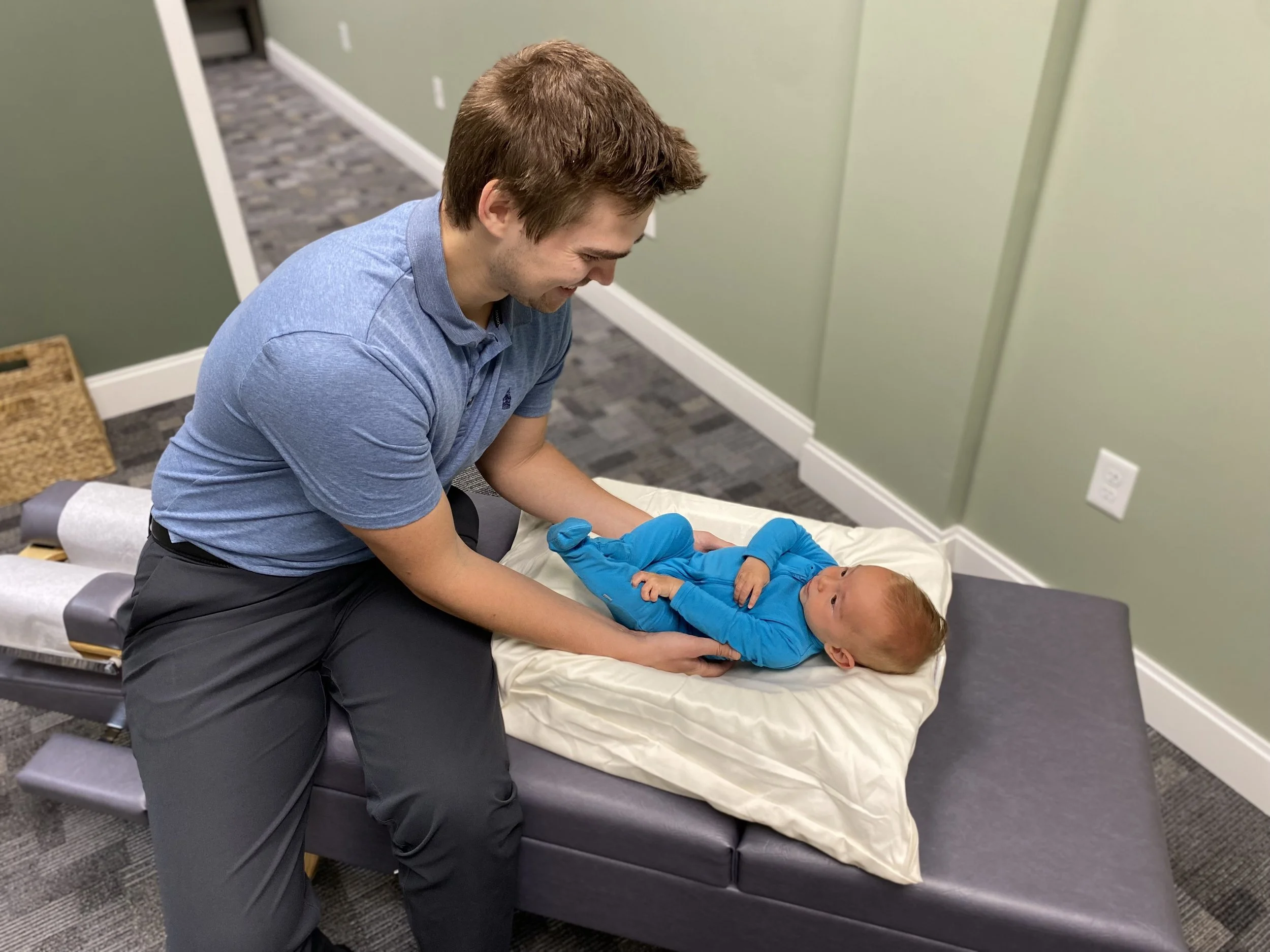 Dr. Austin Krantz providing a chiropractic adjustment to an infant