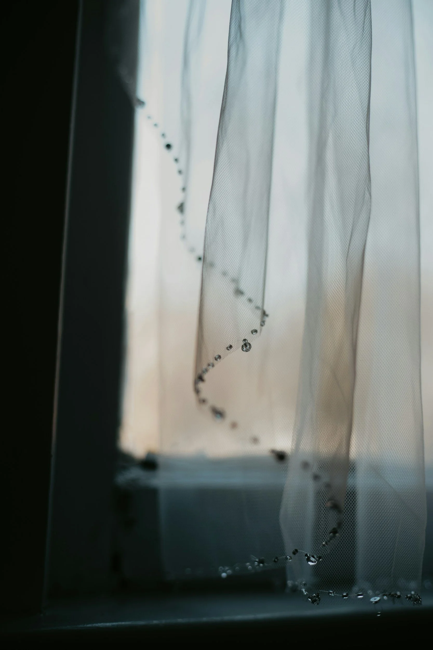 Soft natural light filtering through a cream sheer curtain at a window.