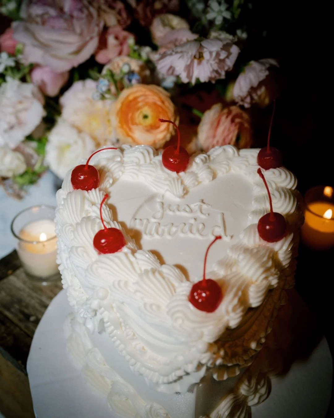Just married&hellip;with a cherry on top. 🍒

A heart-shaped cake like this?
Playful. A little nostalgic. Completely personal.

But the real icing on the cake?
The florals.
Lush. Layered. Everywhere you looked.
On the tables. Overhead. Framing the en