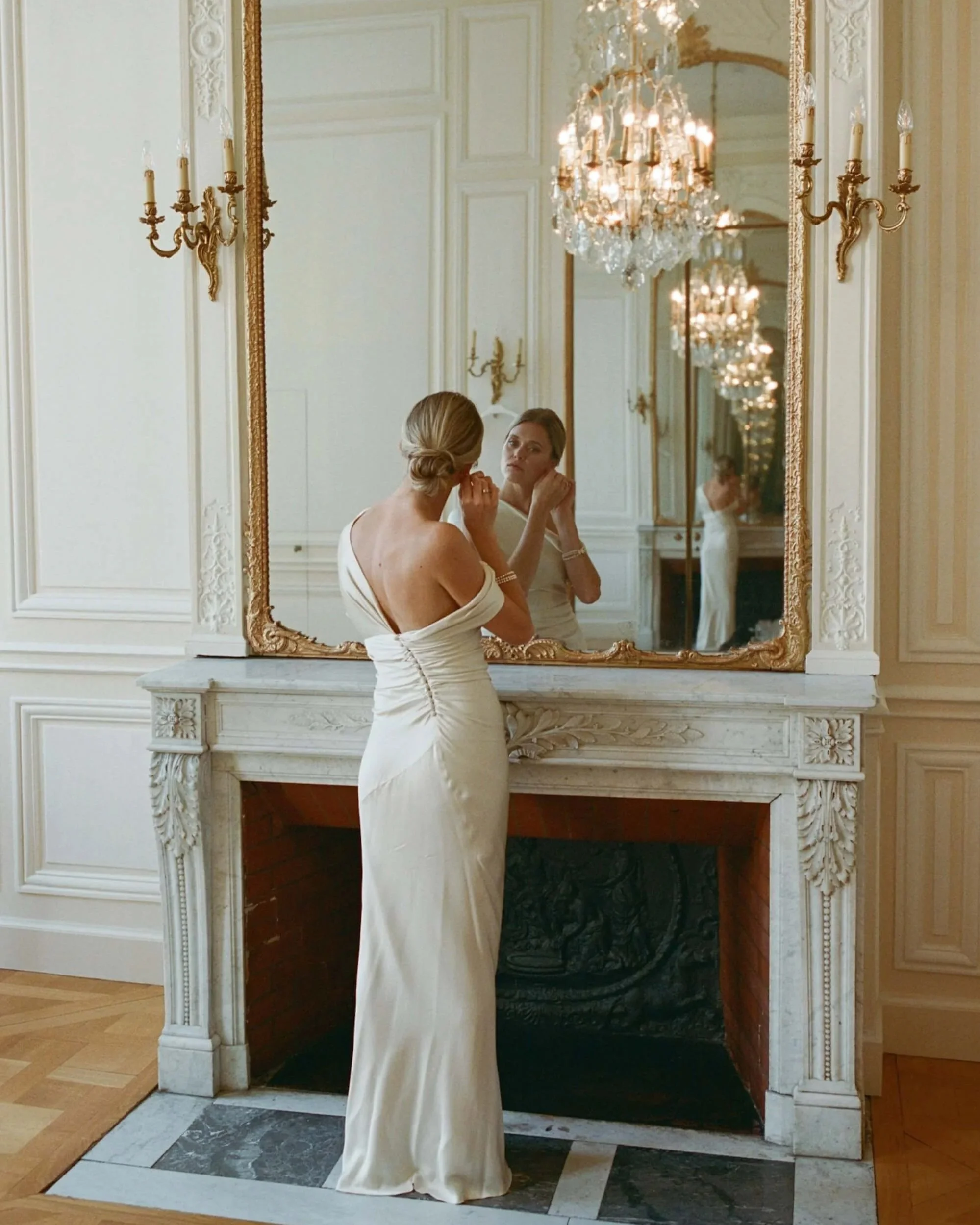 Bride looking in mirror at the Hotel de Poulpry in Paris