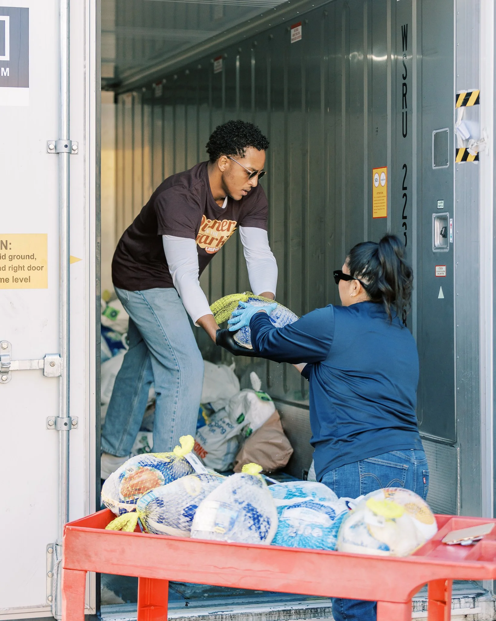Union Station Homeless Employee and USHS Volunteer load turkeys into a fridge for the USHS annual Dinner in the Park serving over 6,000 Thanksgiving meals.