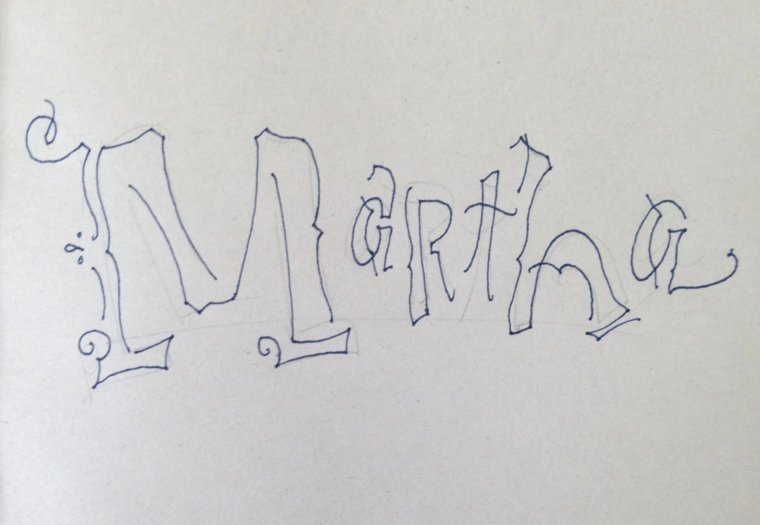 Hand-drawn cursive typography spelling "Martha" on paper.