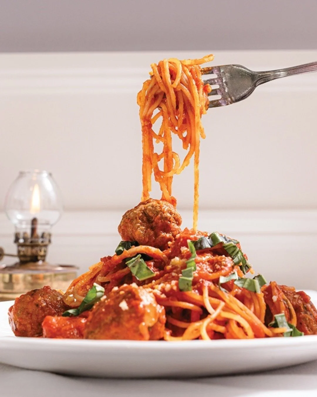 Spaghetti and meatballs topped with basil and parmesan.

Photo by @posesawkwardly