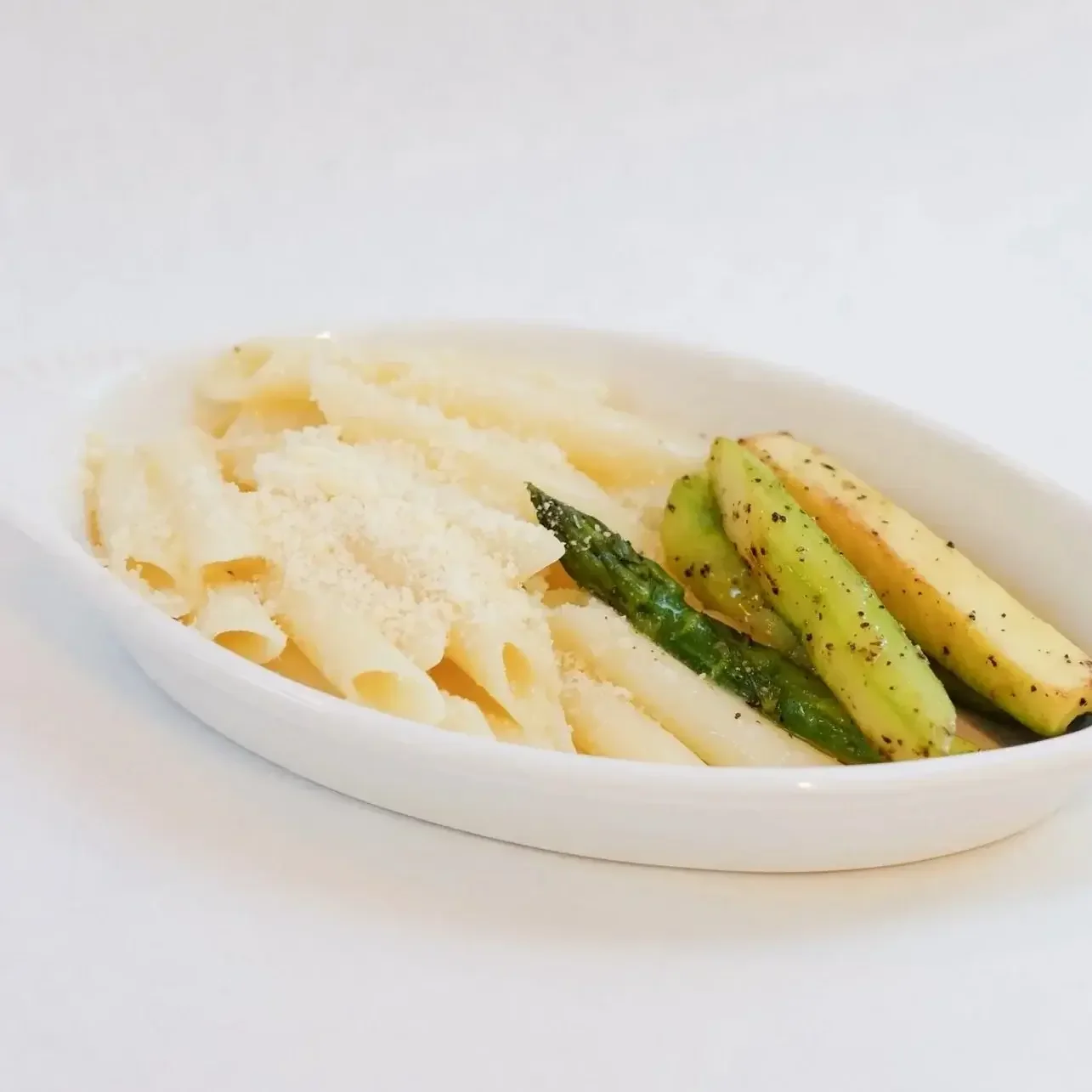Kid-friendly buttered penne pasta topped with parmesan cheese, served with roasted asparagus and zucchini at Lilac Montecito.