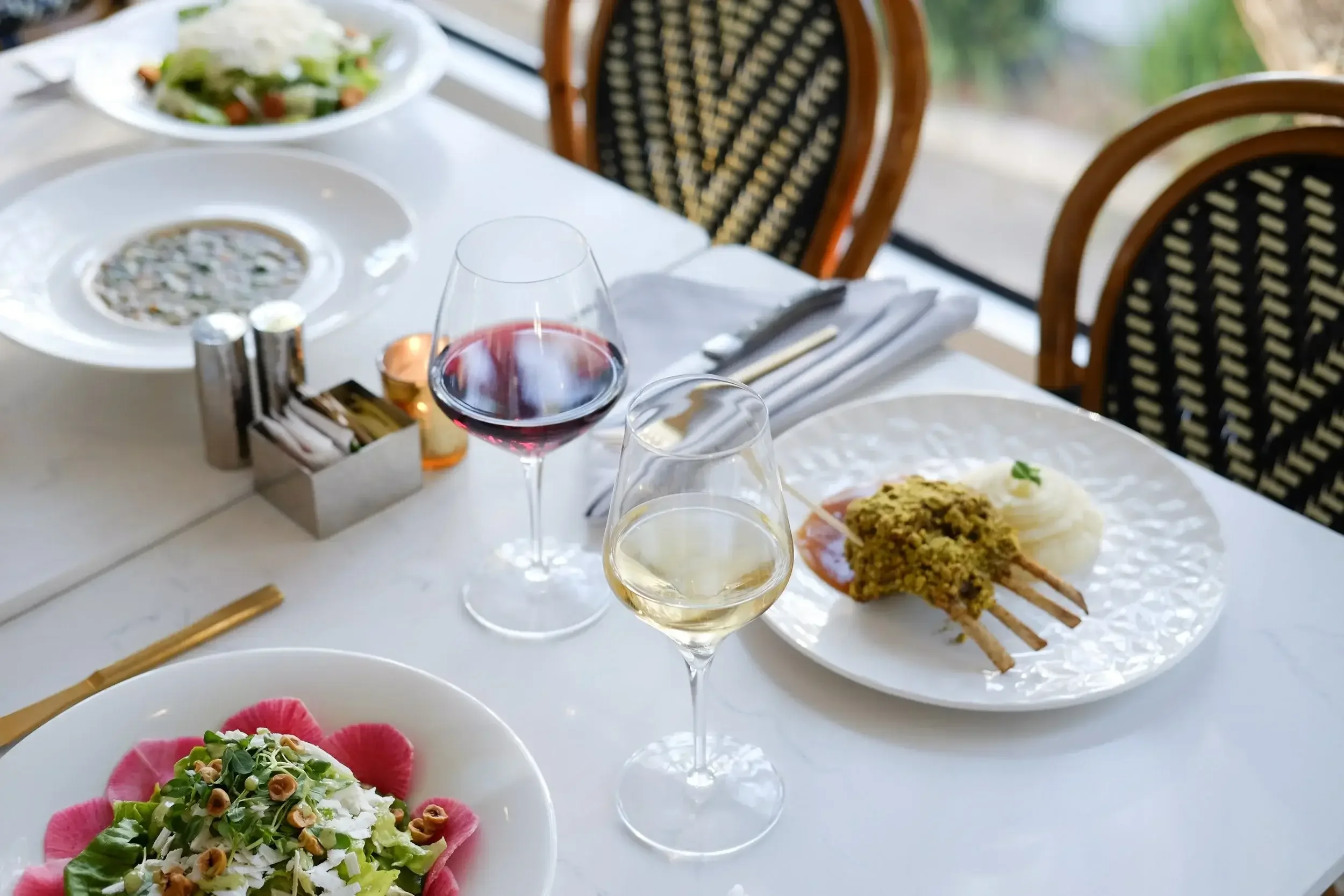 Dinner plates and wine at Lilac Montecito, showcasing the dining experience available with a restaurant gift card.”