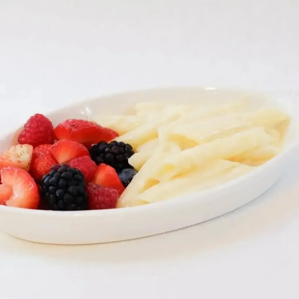 Simple kid-friendly buttered penne pasta served with a side of fresh raspberries, blackberries, and strawberries at Lilac Montecito.