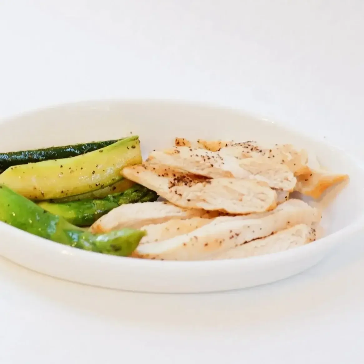 Tender sliced grilled chicken breast served with roasted asparagus and zucchini, a healthy kids menu favorite at Lilac Montecito.