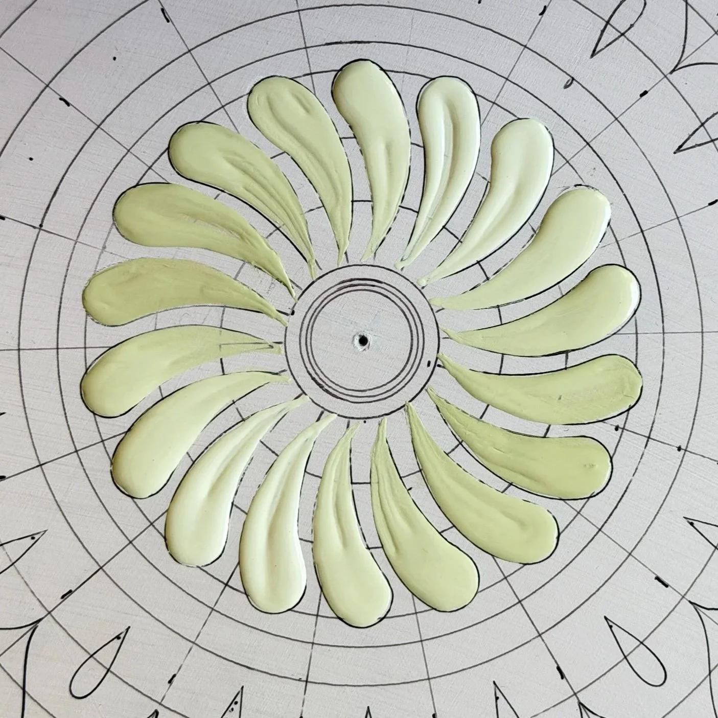 Sliced green zucchini arranged in a circular pattern on a wire cooling rack.