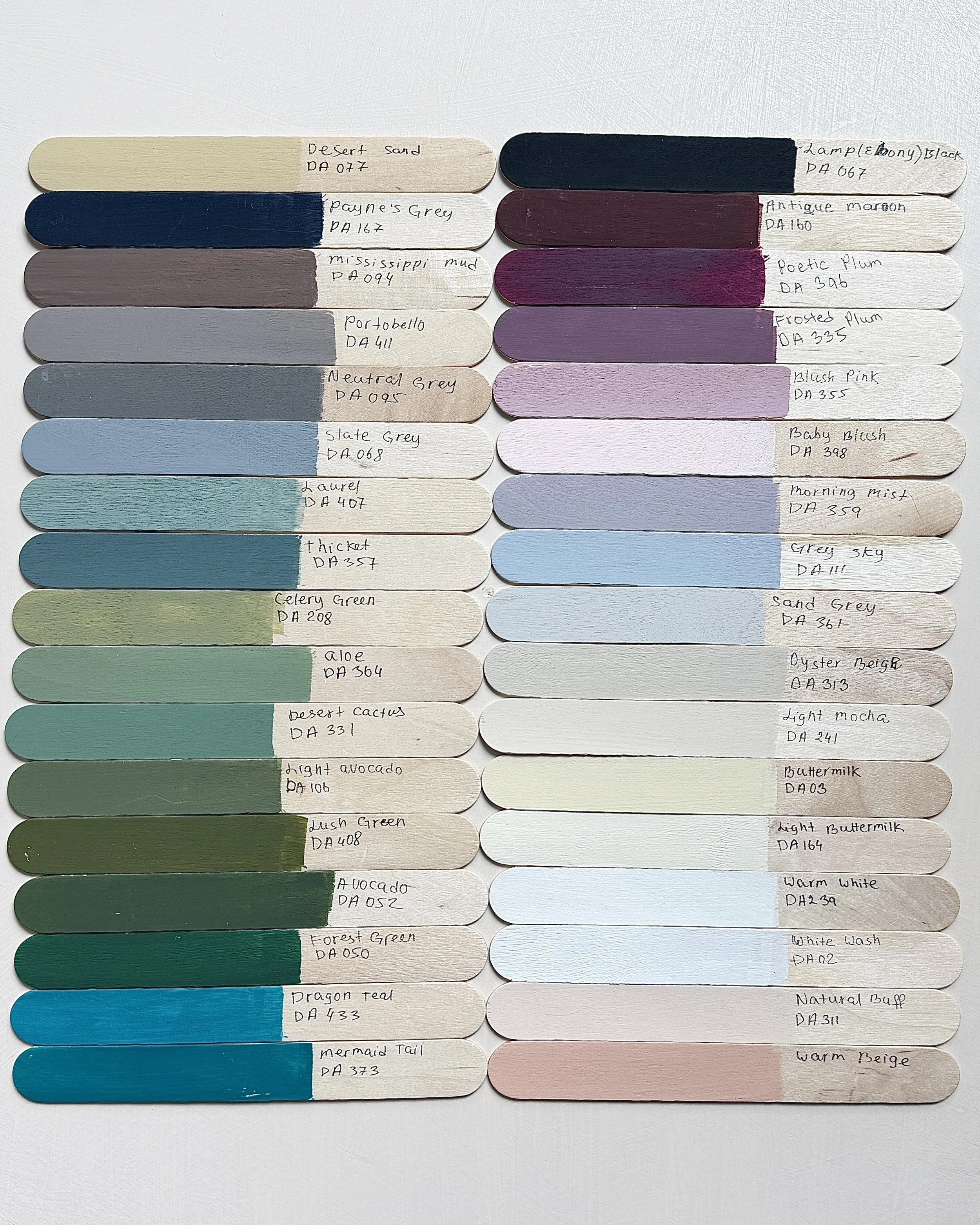 Color swatches arranged on two columns, each with handwritten labels and paint codes, ranging from desert sand to warm beige, with shades of grey, green, blue, pink, and white.