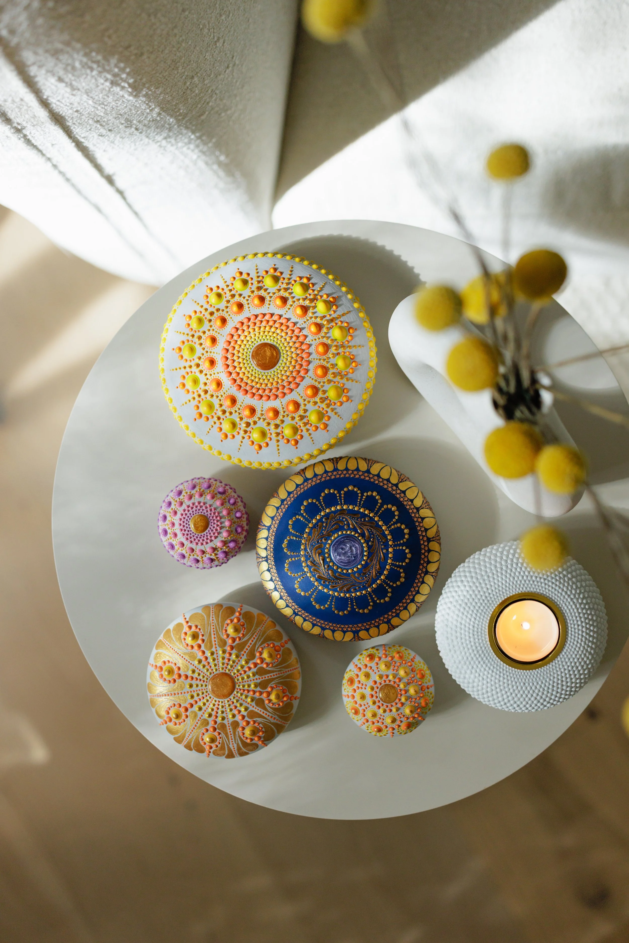 Colorful dot art ceramics arranged on a white table