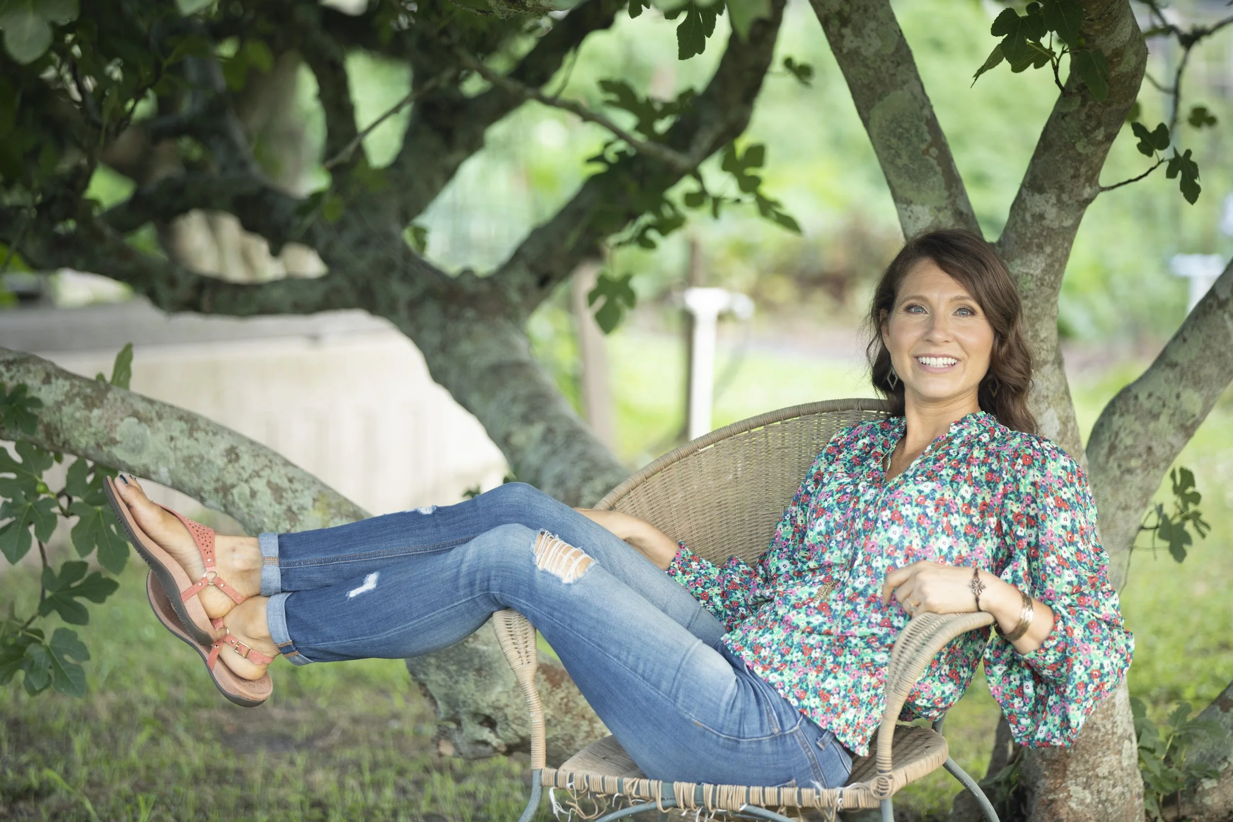 Sheila Tucker LMFTC-S, individual and couples therapist with heart mind & soul counseling in Hilton Head Island, SC casually sitting under a fig tree at the Sea Pines garden.