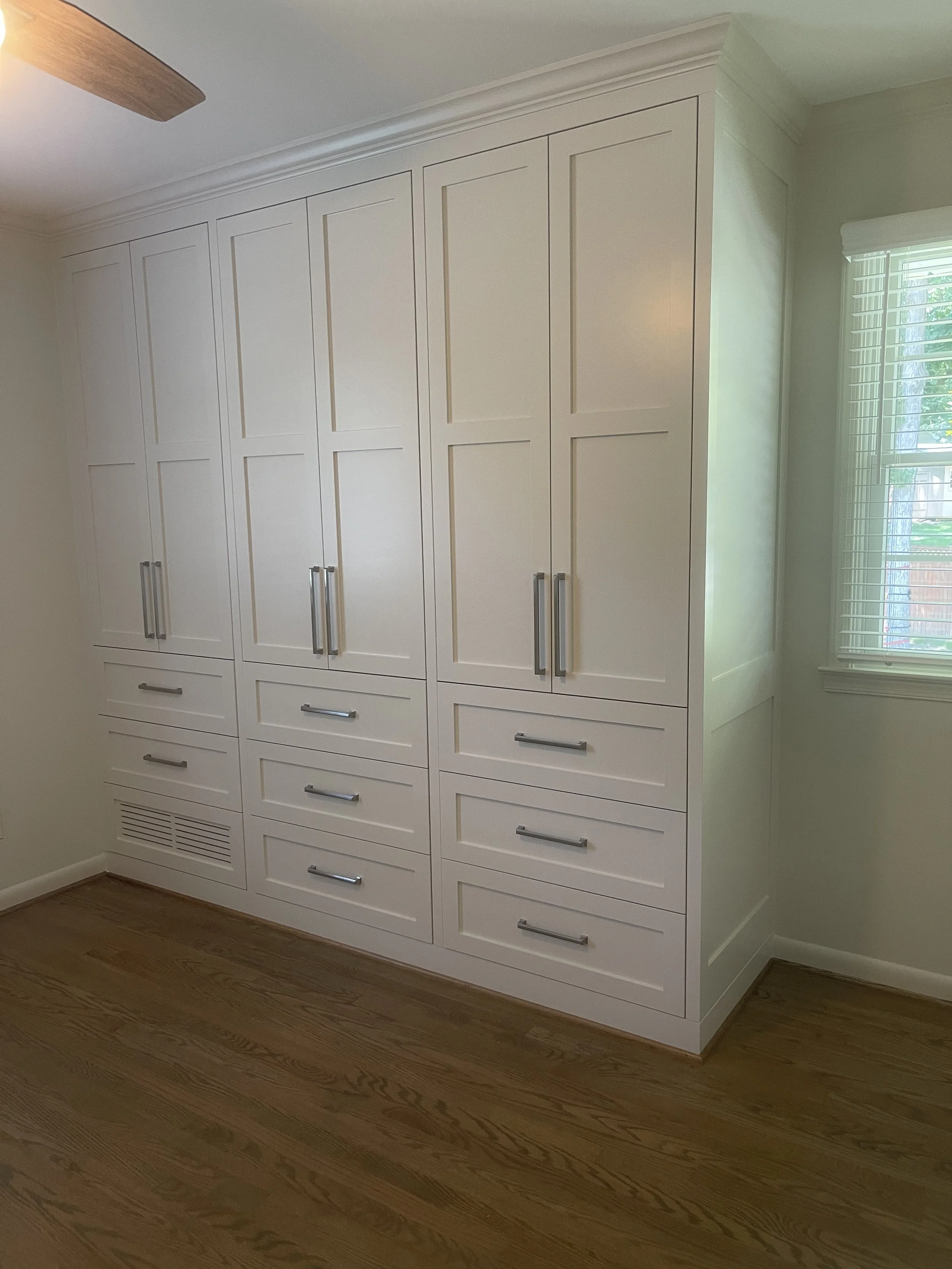 Custom Master Bedroom Armoire with upper hanging storage and lower drawer storage with a custom air supply vent and HVAC technician access.