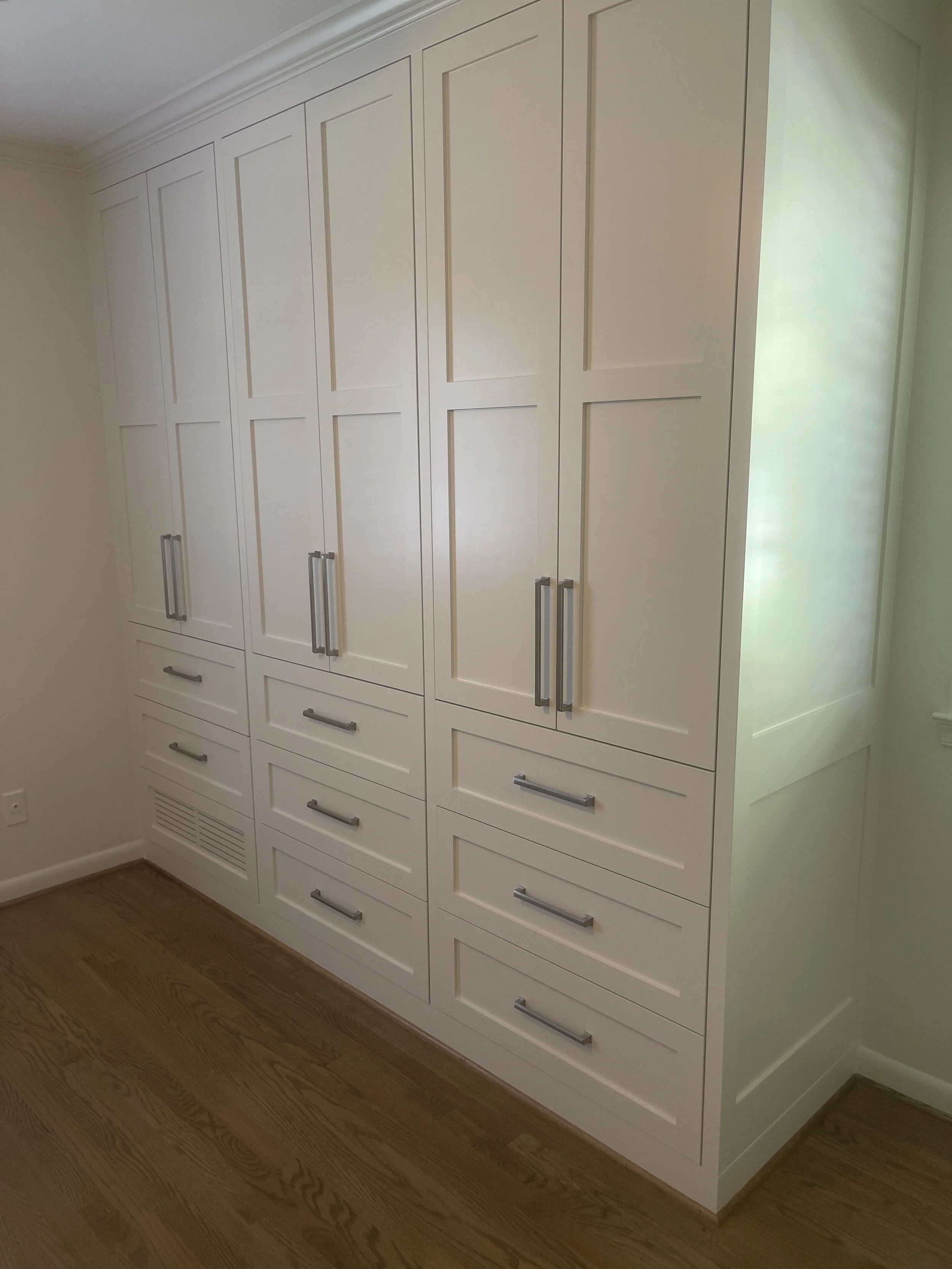 Custom Master Bedroom Armoire with upper hanging storage and lower drawer storage with a custom air supply vent and HVAC technician access.