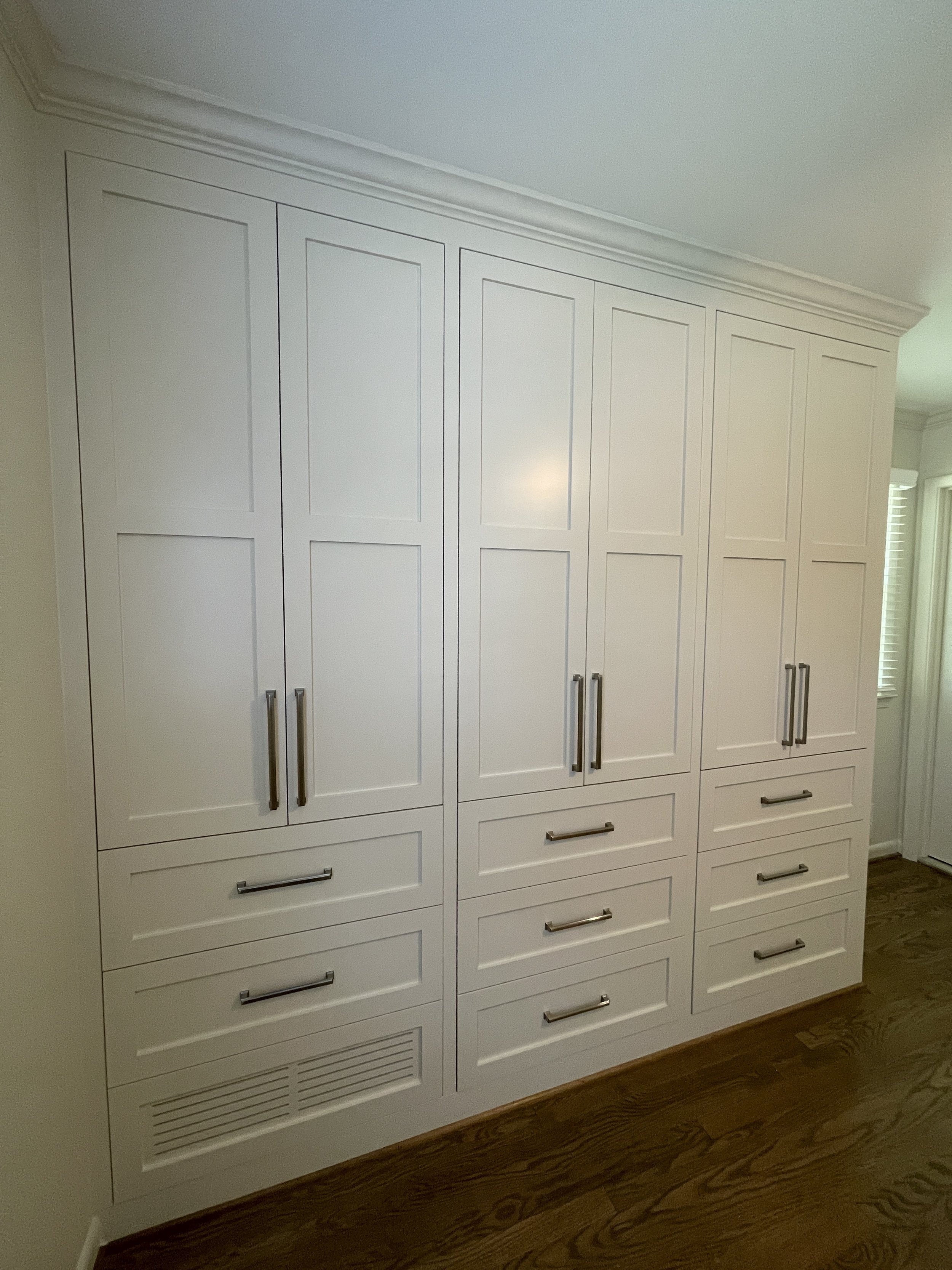 Custom Master Bedroom Armoire with upper hanging storage and lower drawer storage with a custom air supply vent and HVAC technician access.