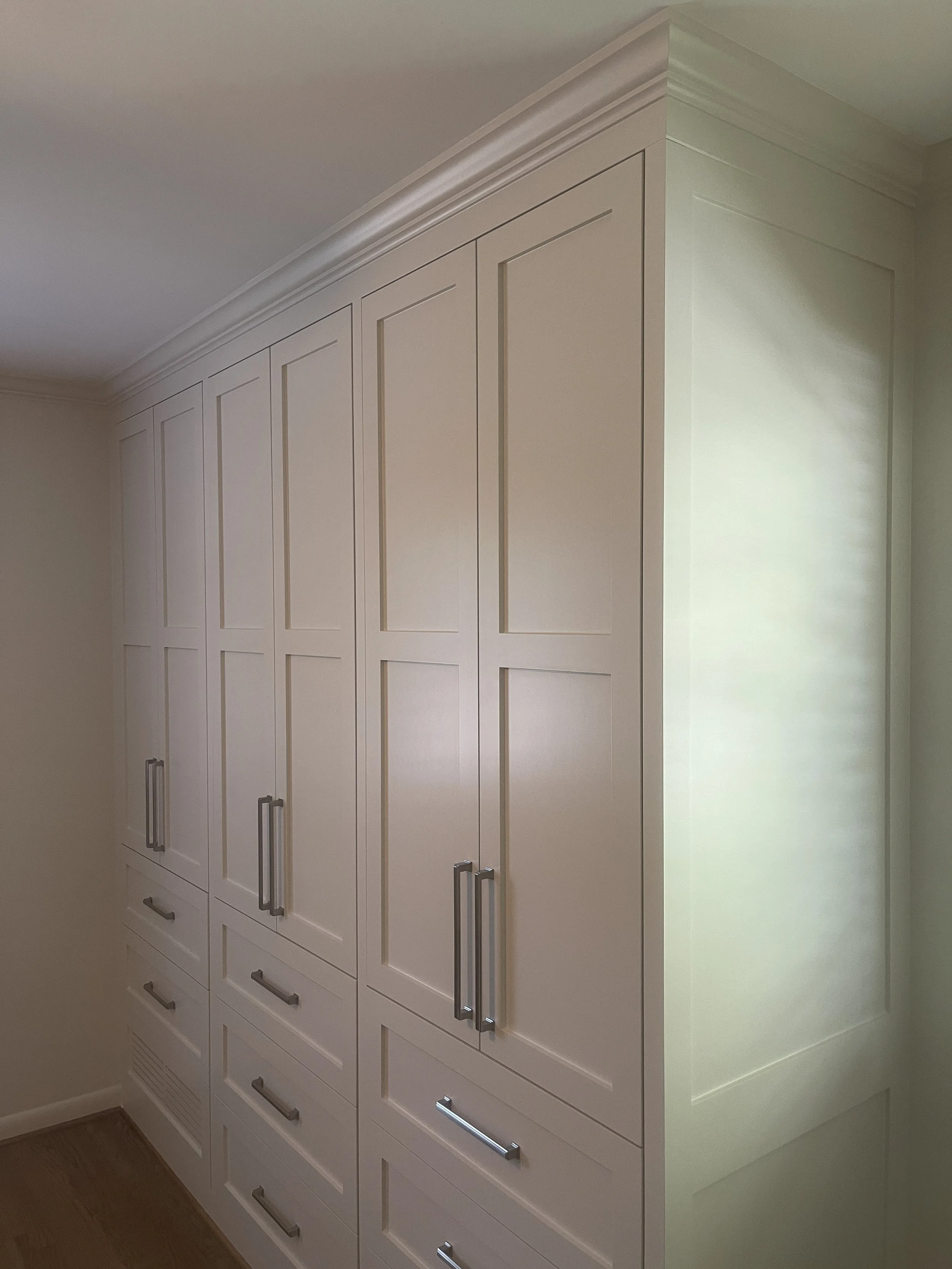 Custom Master Bedroom Armoire with upper hanging storage and lower drawer storage with a custom air supply vent and HVAC technician access.