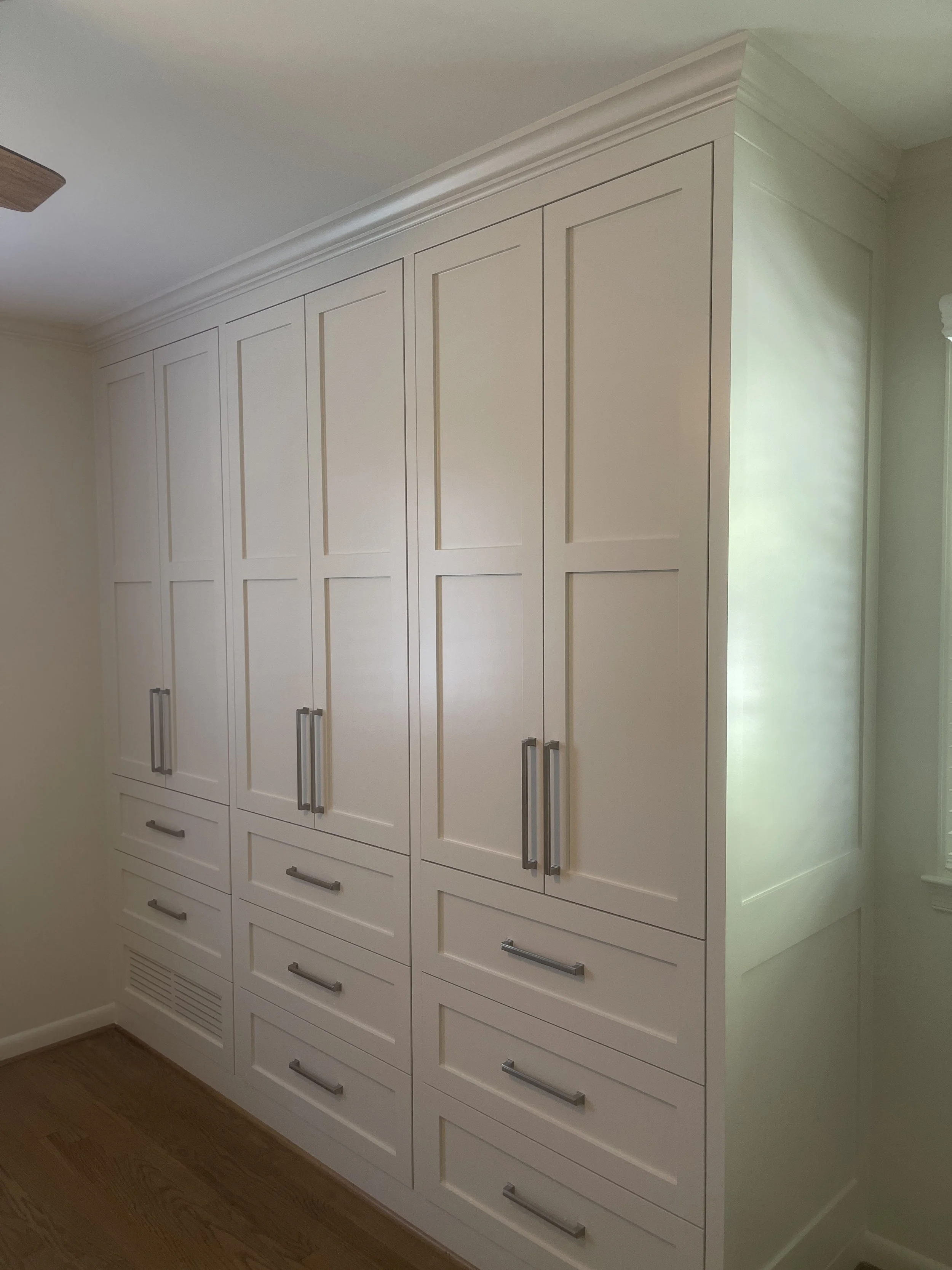 Custom Master Bedroom Armoire with upper hanging storage and lower drawer storage with a custom air supply vent and HVAC technician access.
