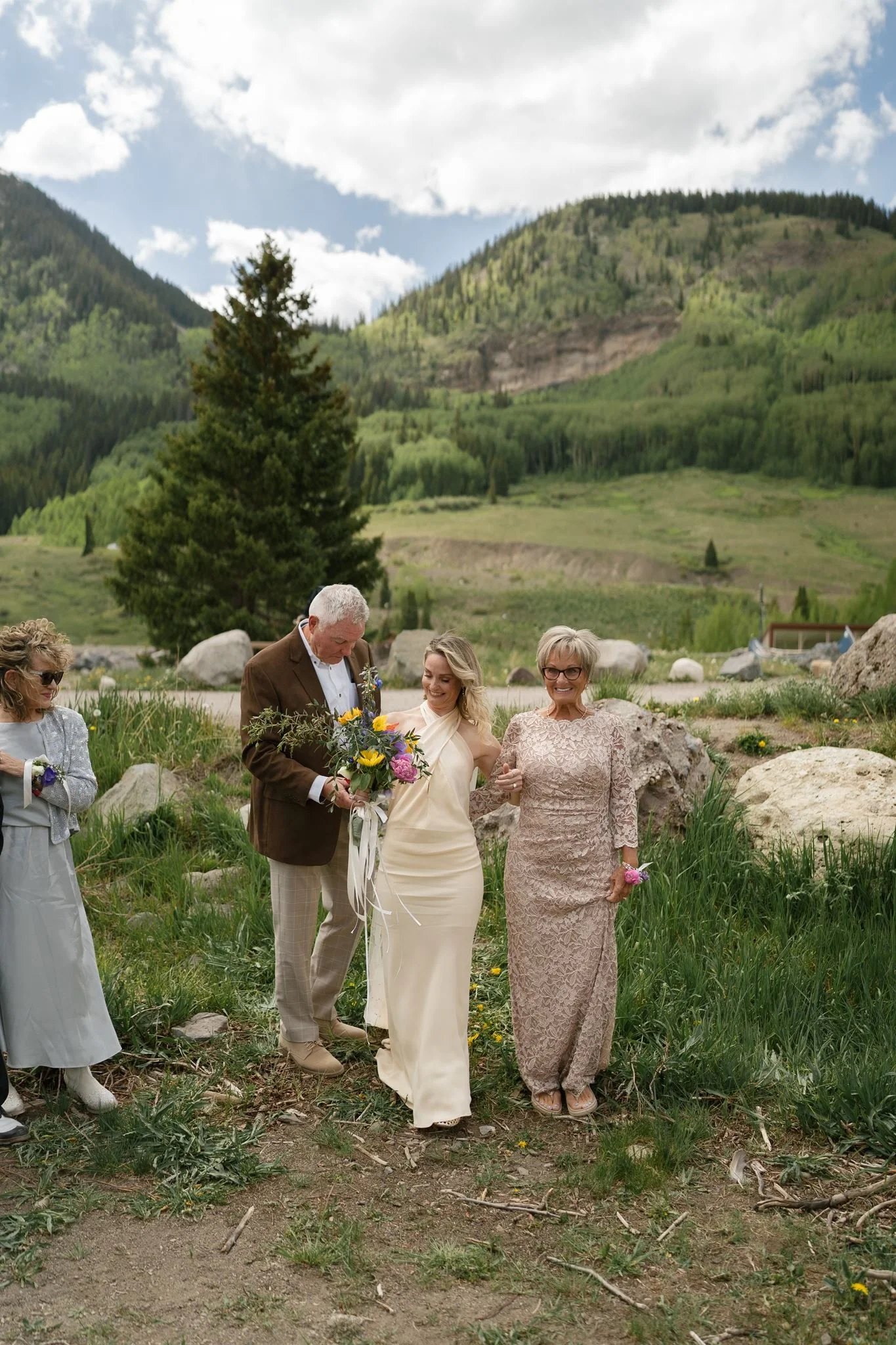 mom and dad help the bride down the aisle