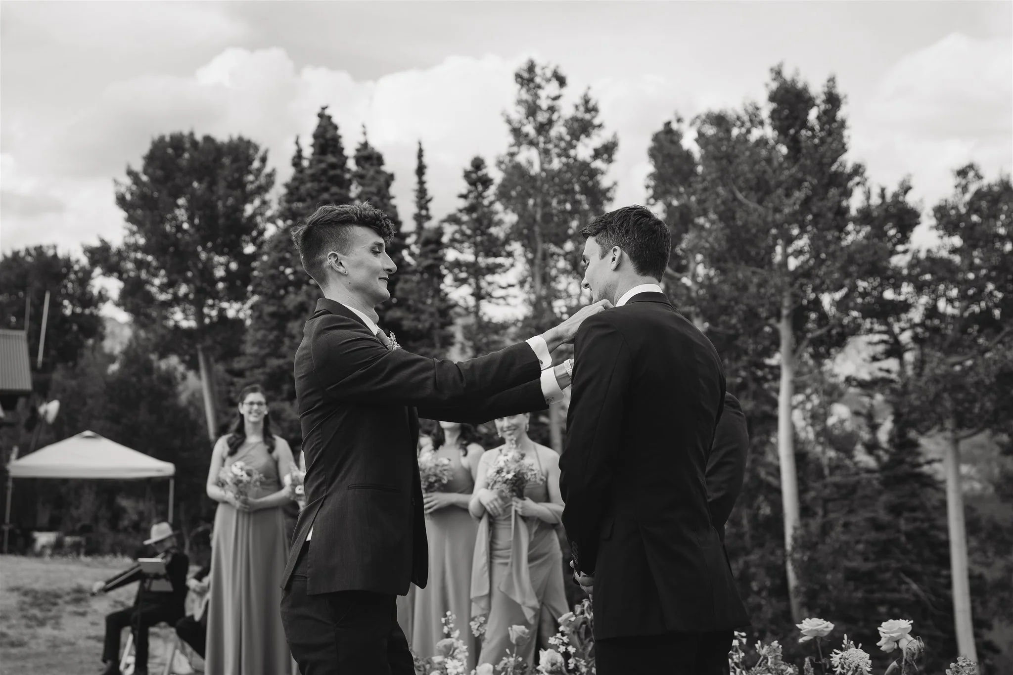 the groom's brother adjusting his tie before the ceremony