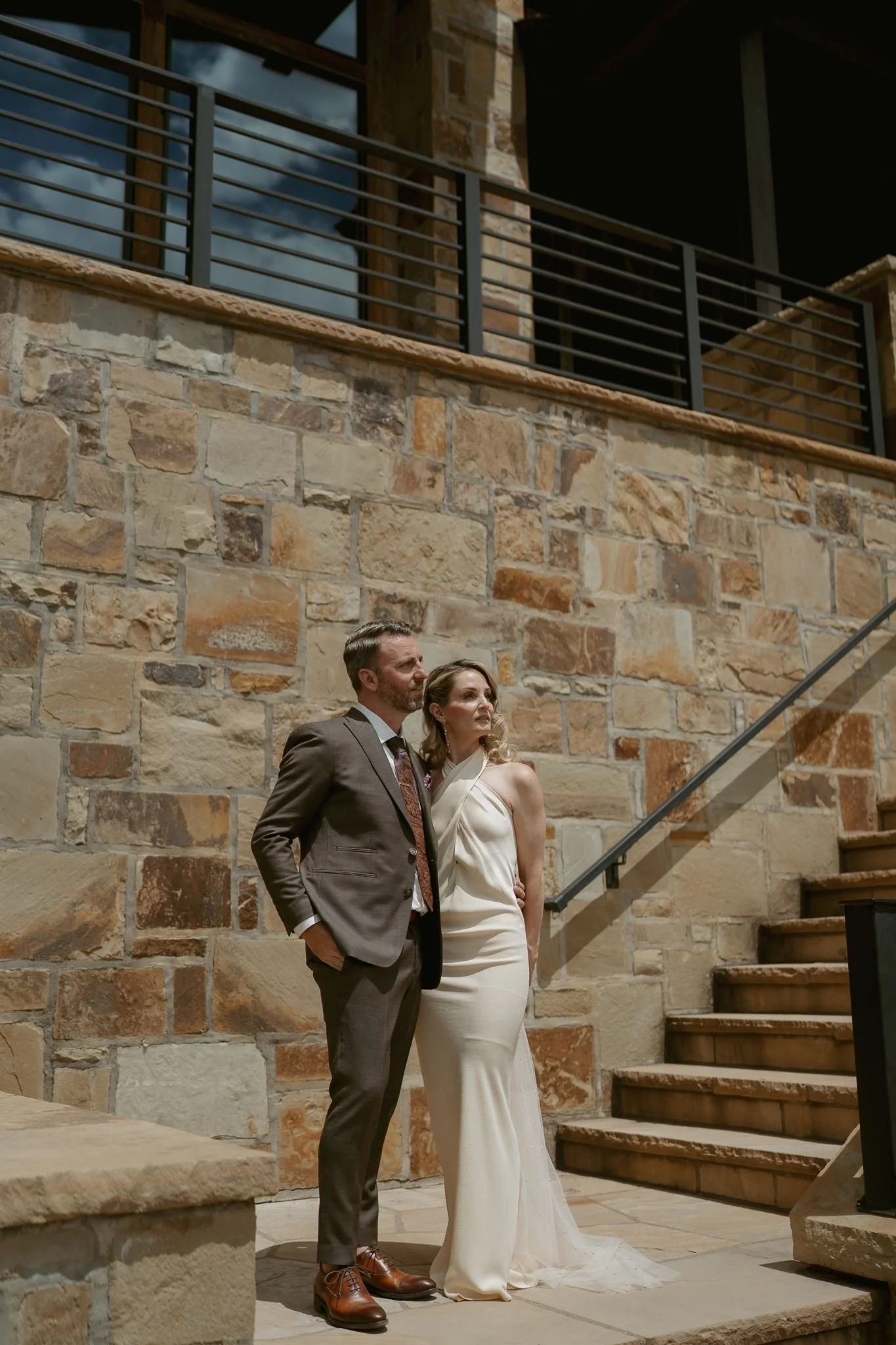 bride and groom stand outside their Airbnb